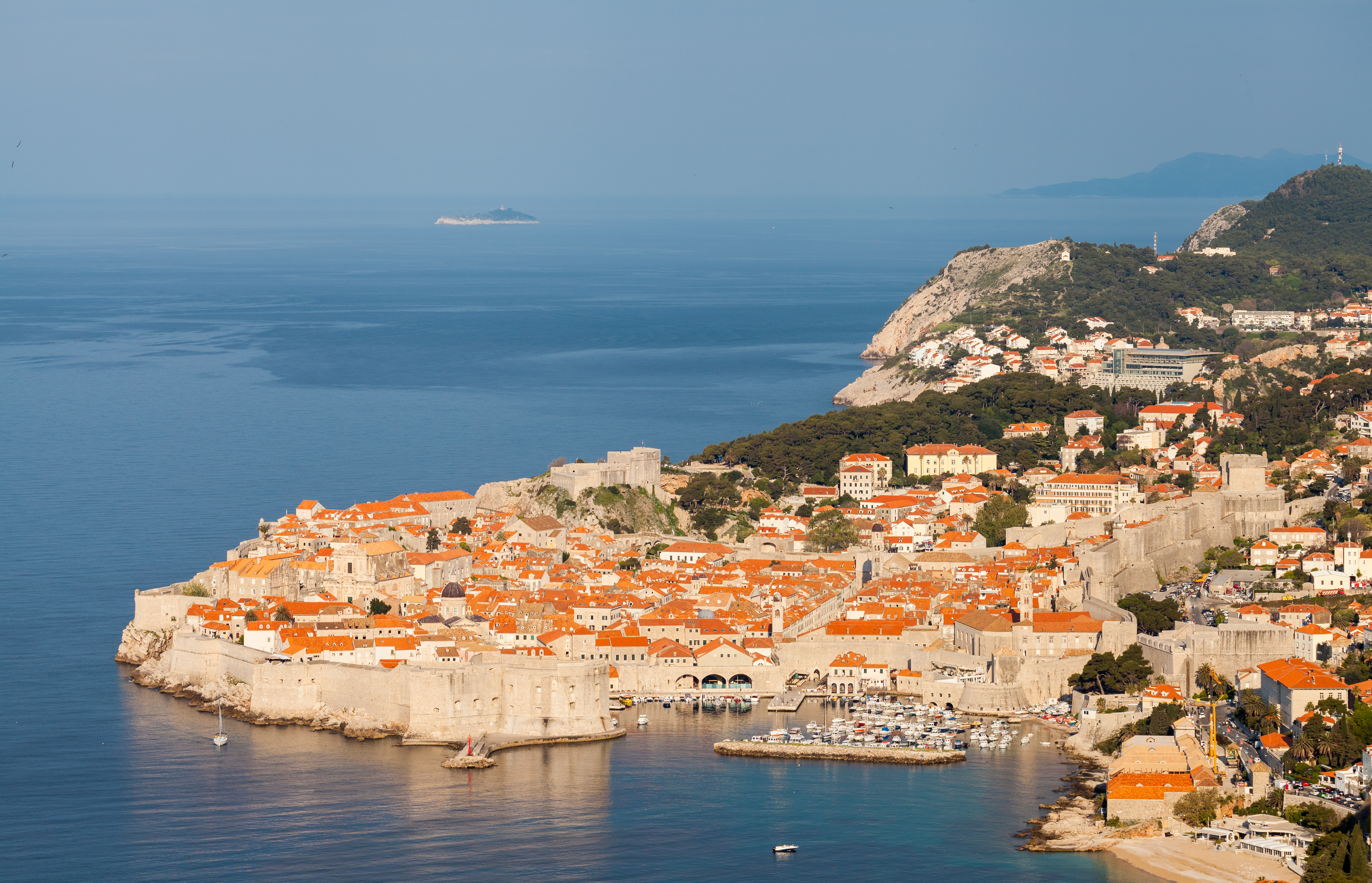 Aerial view of Dubrovnik old town with its medieval city walls and red-tiled rooftops along the Adriatic coast Dubrovnik's medieval old city rising from the Adriatic on a rocky peninsula, its orange-roofed buildings enclosed by centuries-old limestone city walls