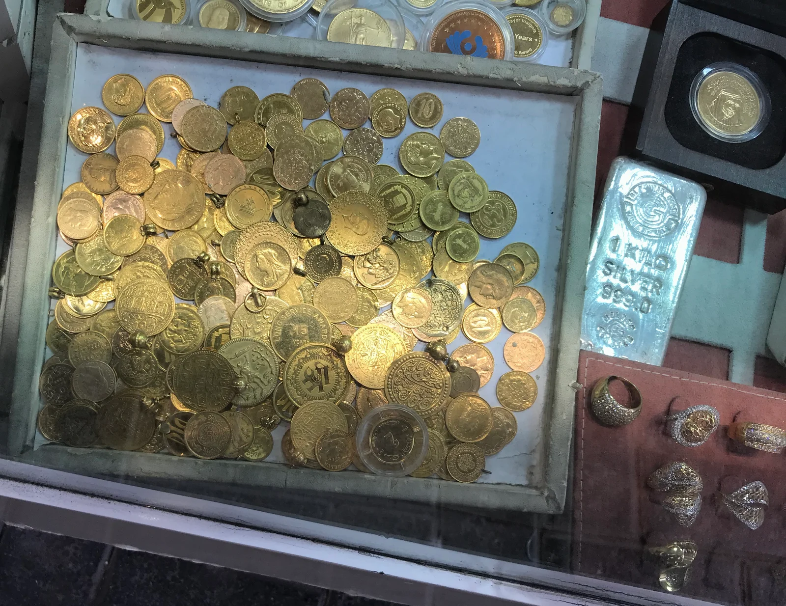 Gold coins and small bars laid out for sale at a dealer in the Dubai Gold Souk