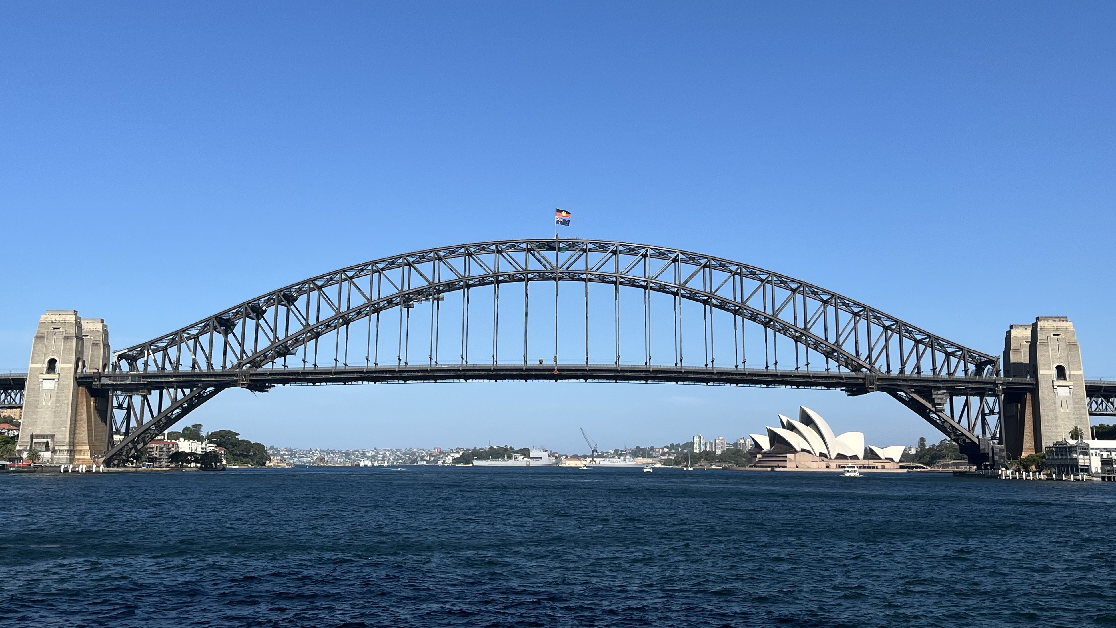Sydney Harbour Bridge arch spanning the harbour with the city skyline in the background