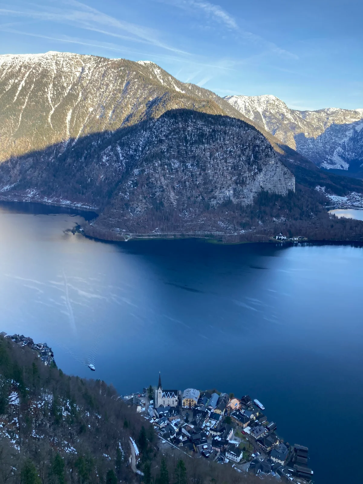 Aerial view of Hallstatt village and the Hallstättersee lake photographed from the Hallstatt Skywalk platform, rooftops and church spire far below