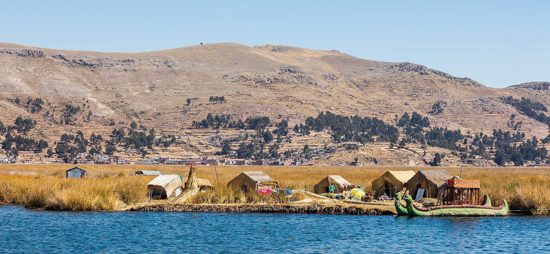 Uros floating islands made of totora reeds on Lake Titicaca with traditional thatched structures and colorful boats