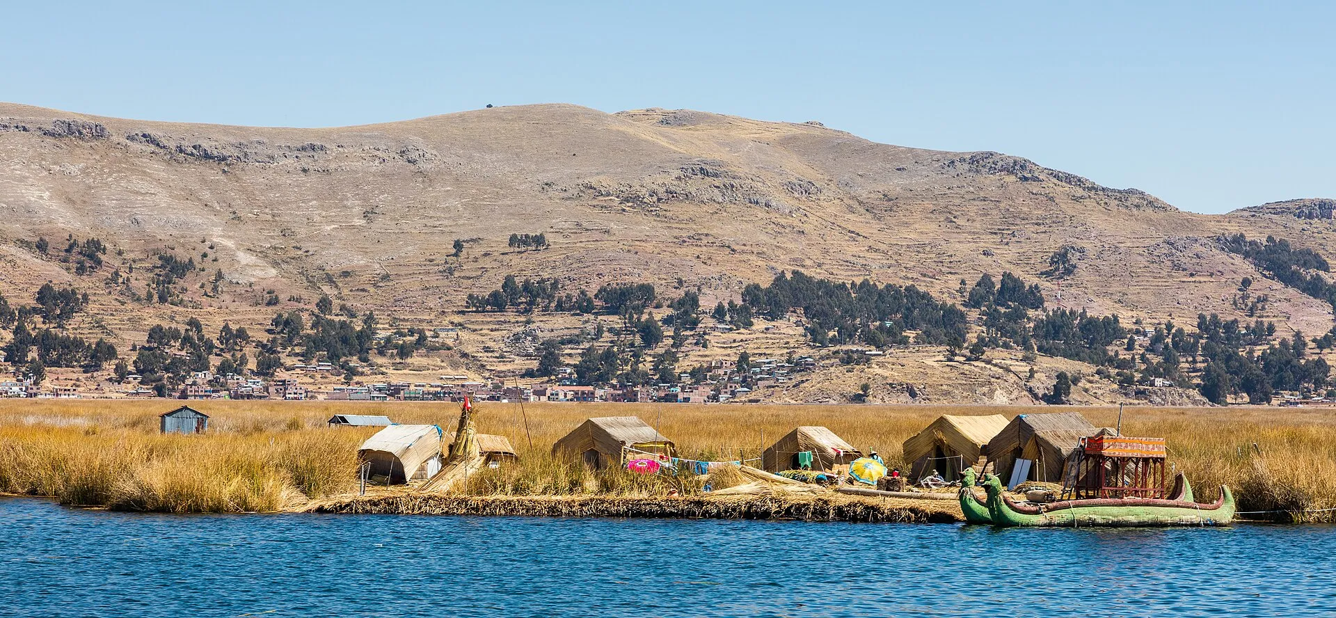 Uros floating islands made of totora reeds on Lake Titicaca with traditional thatched structures and colorful boats