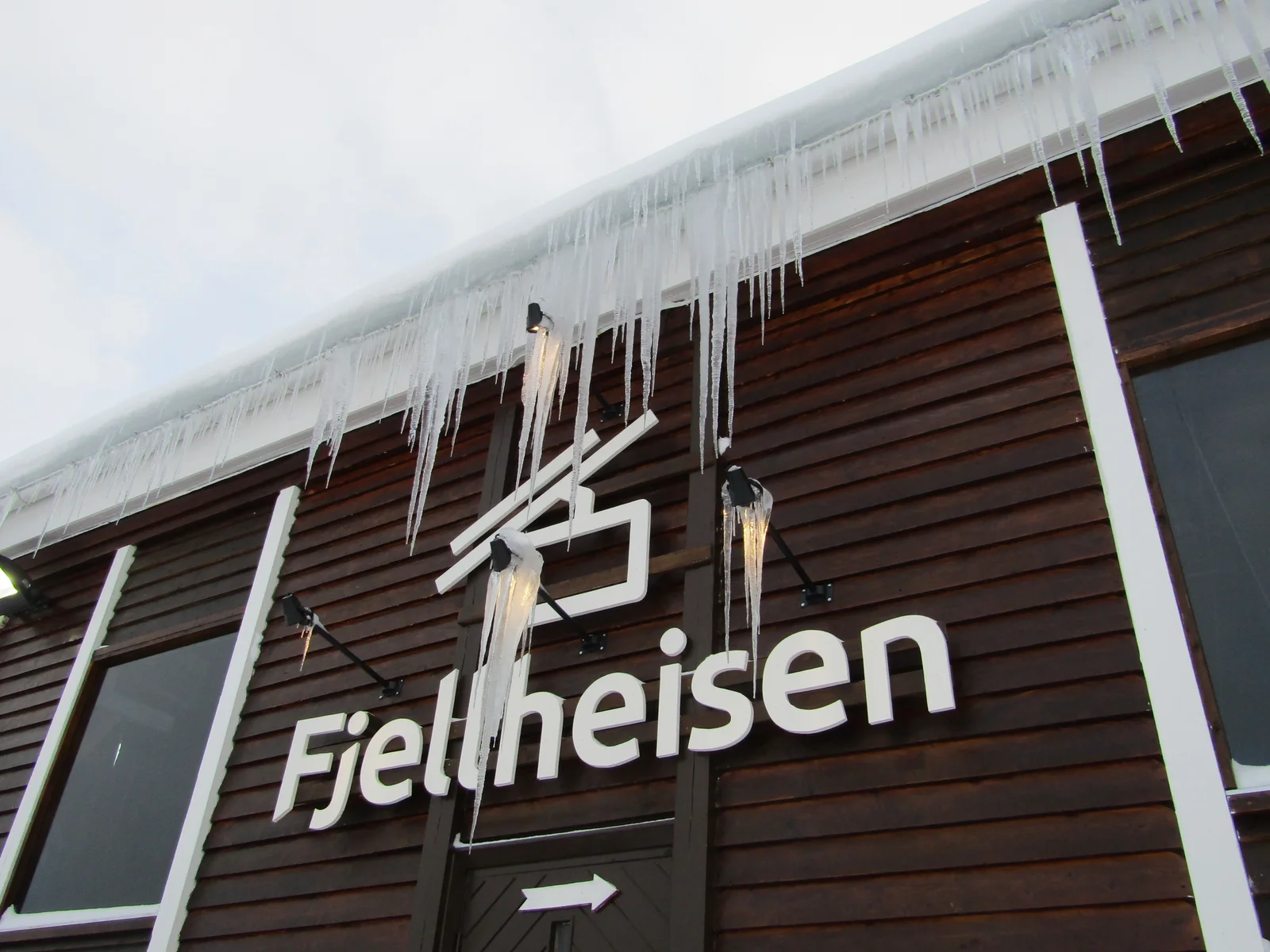 A Fjellheisen cable car climbing above snowy Tromsø toward the Storsteinen viewpoint