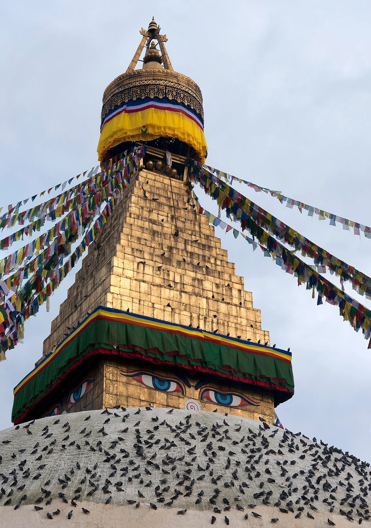 Boudhanath Stupa with colourful prayer flags rising above the surrounding buildings in Kathmandu