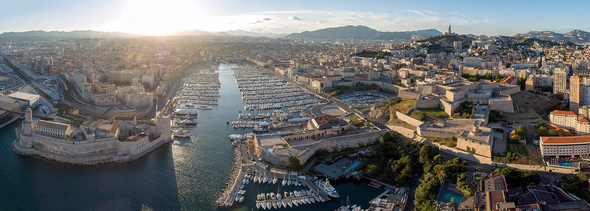 Panoramic view of the Vieux-Port harbor in Marseille with boats and Notre-Dame de la Garde