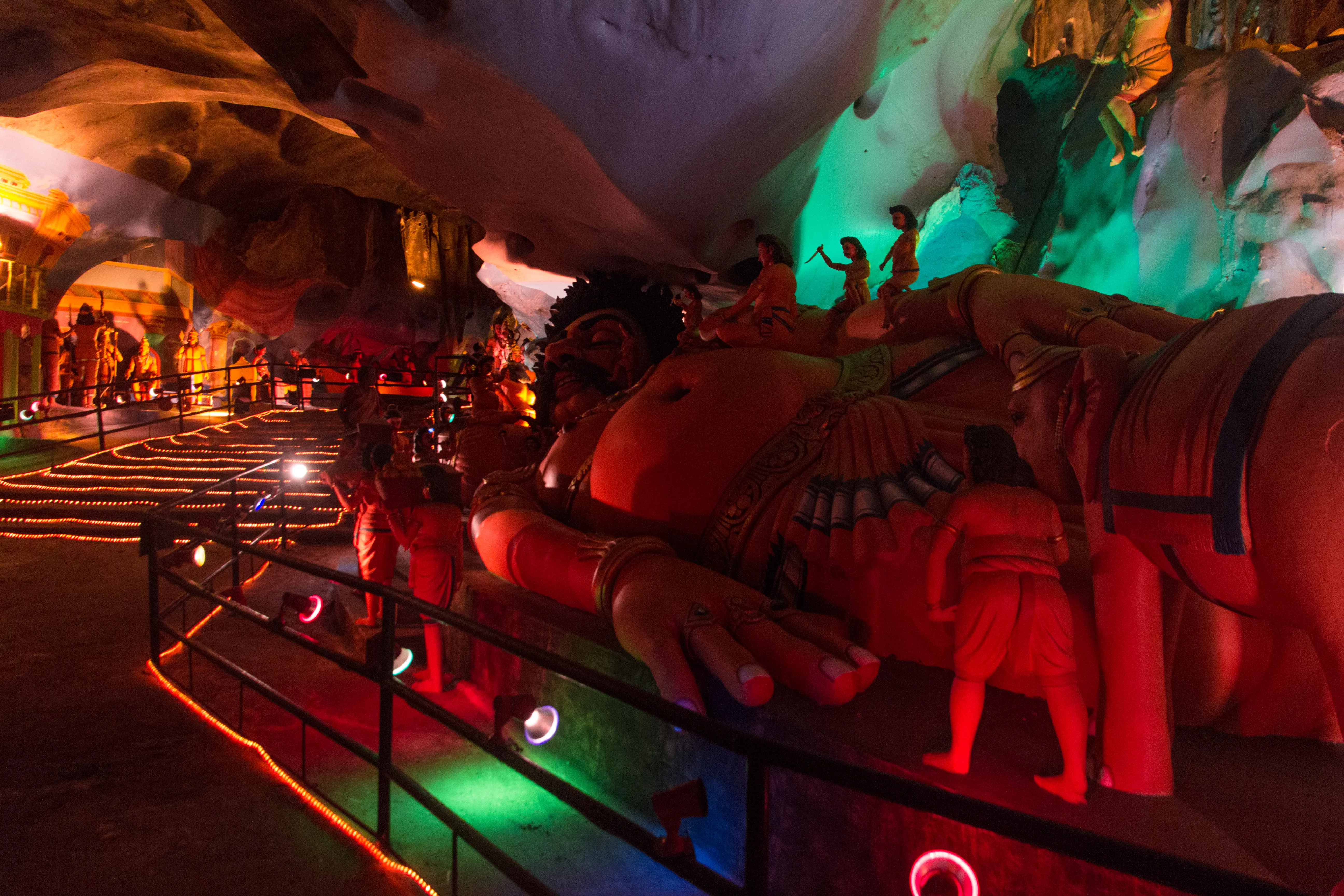 The entrance to Batu Caves Temple Cave with its towering golden Lord Murugan statue and rainbow-painted staircase in Kuala Lumpur