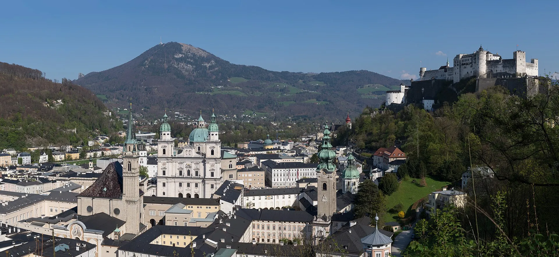 Salzburg's old town with Hohensalzburg Fortress on the hilltop, baroque church domes, and the Salzach River flowing through
