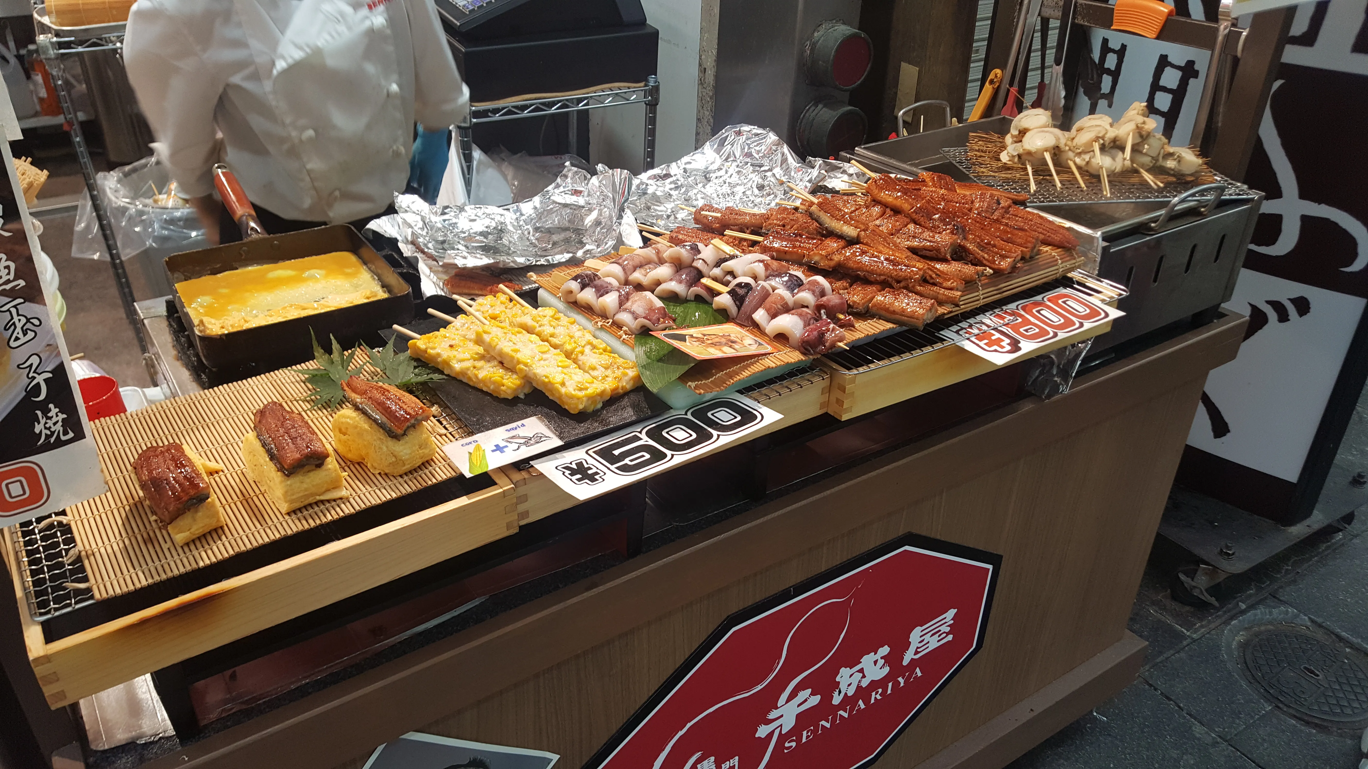 Fresh seafood including crab and shellfish displayed on ice at a stall in Kuromon Market, Osaka