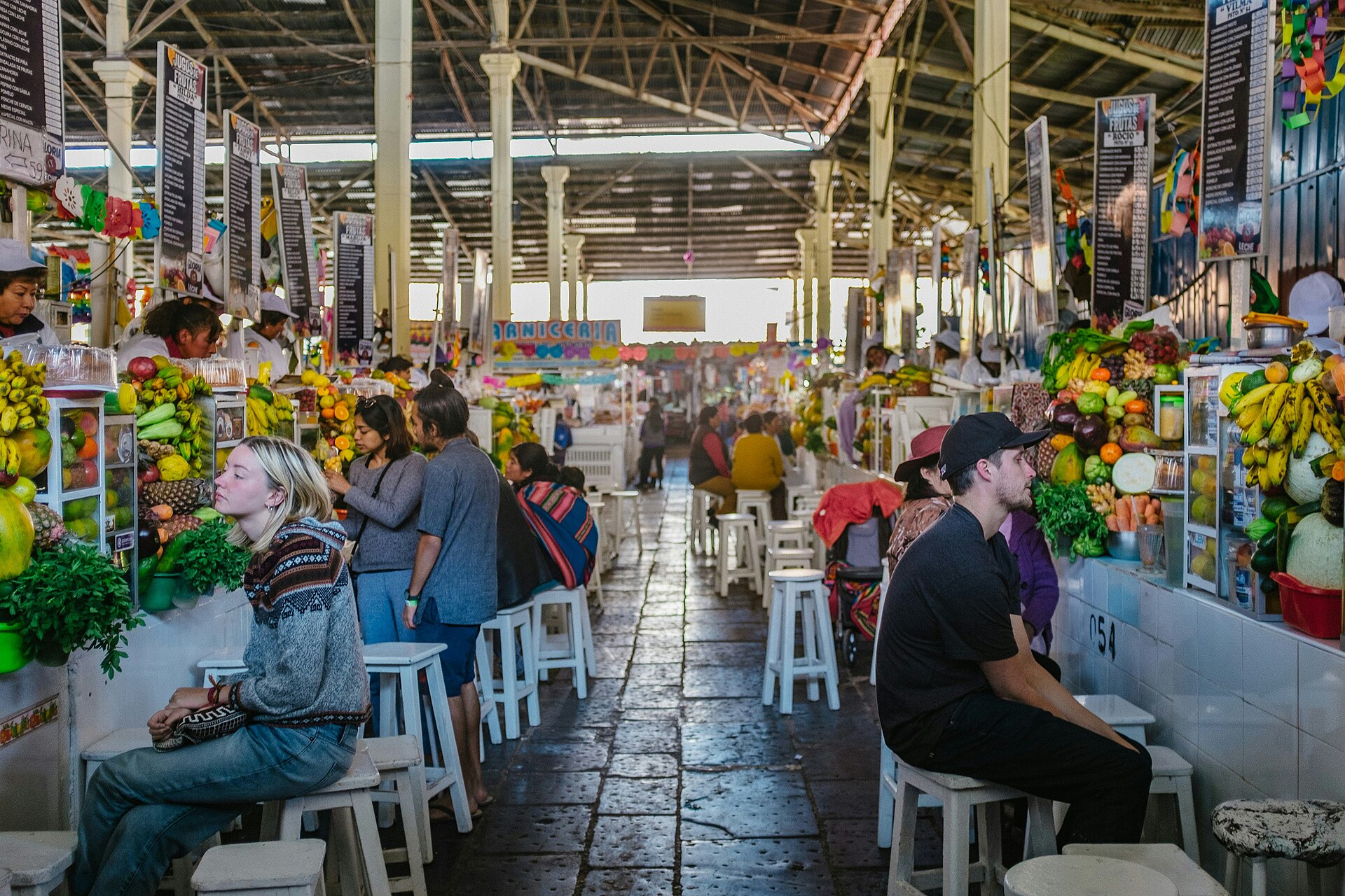 Bustling interior of San Pedro Market in Cusco, Peru, with vendors and colorful produce stalls