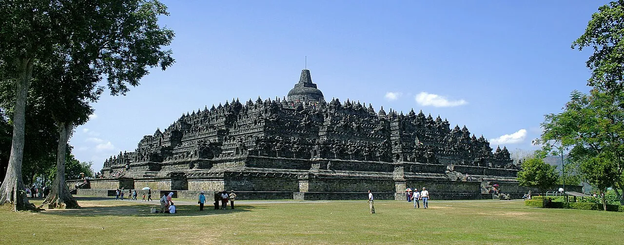 Borobudur Buddhist temple complex with tiered stone platforms and stupas rising above the jungle, Central Java, Indonesia