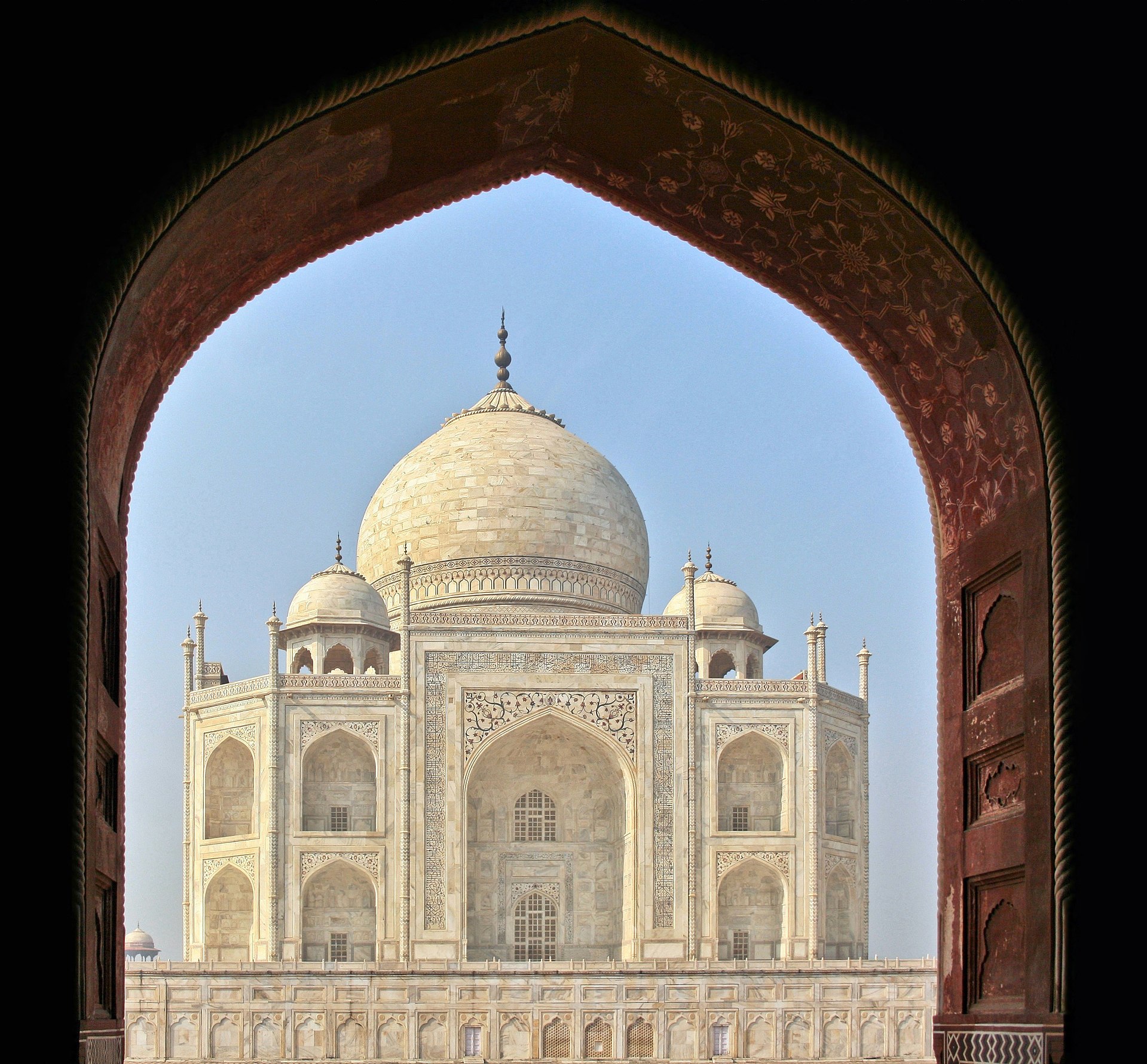 The Taj Mahal and its reflecting pool at sunrise in Agra, India