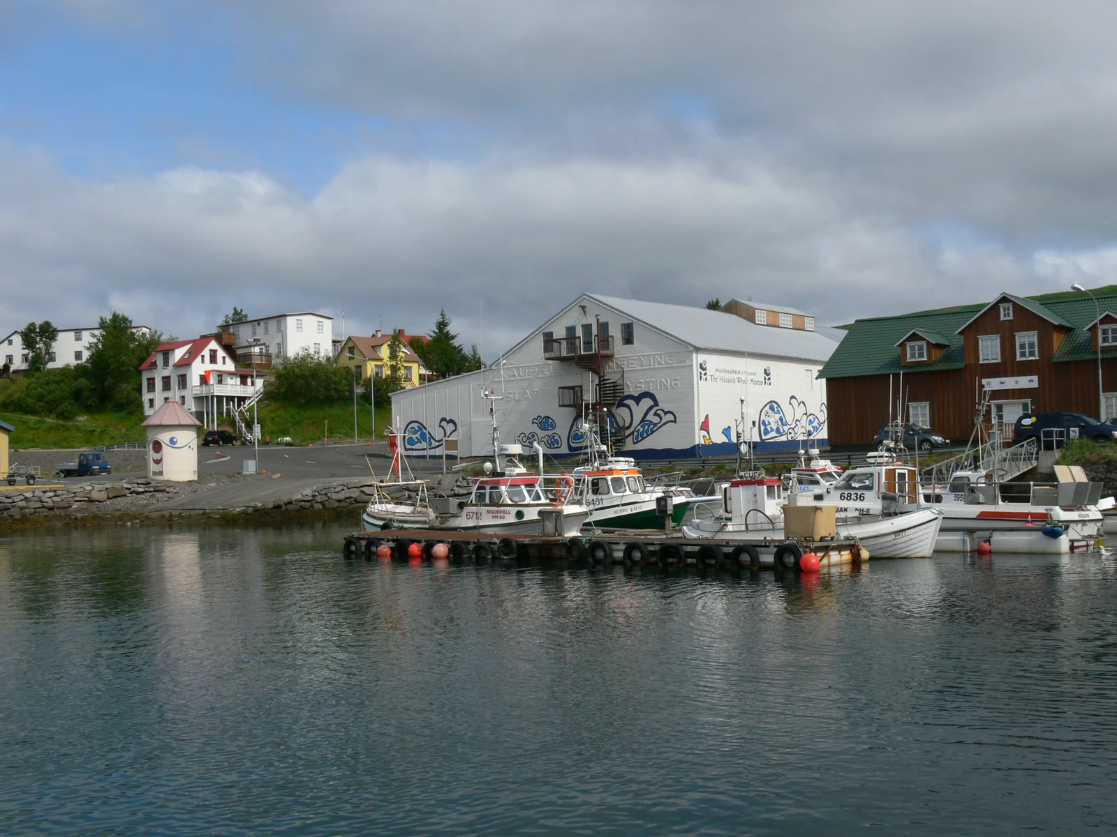 Exterior of the Húsavík Whale Museum, a large timber-and-stone building, seen from the harbourfront