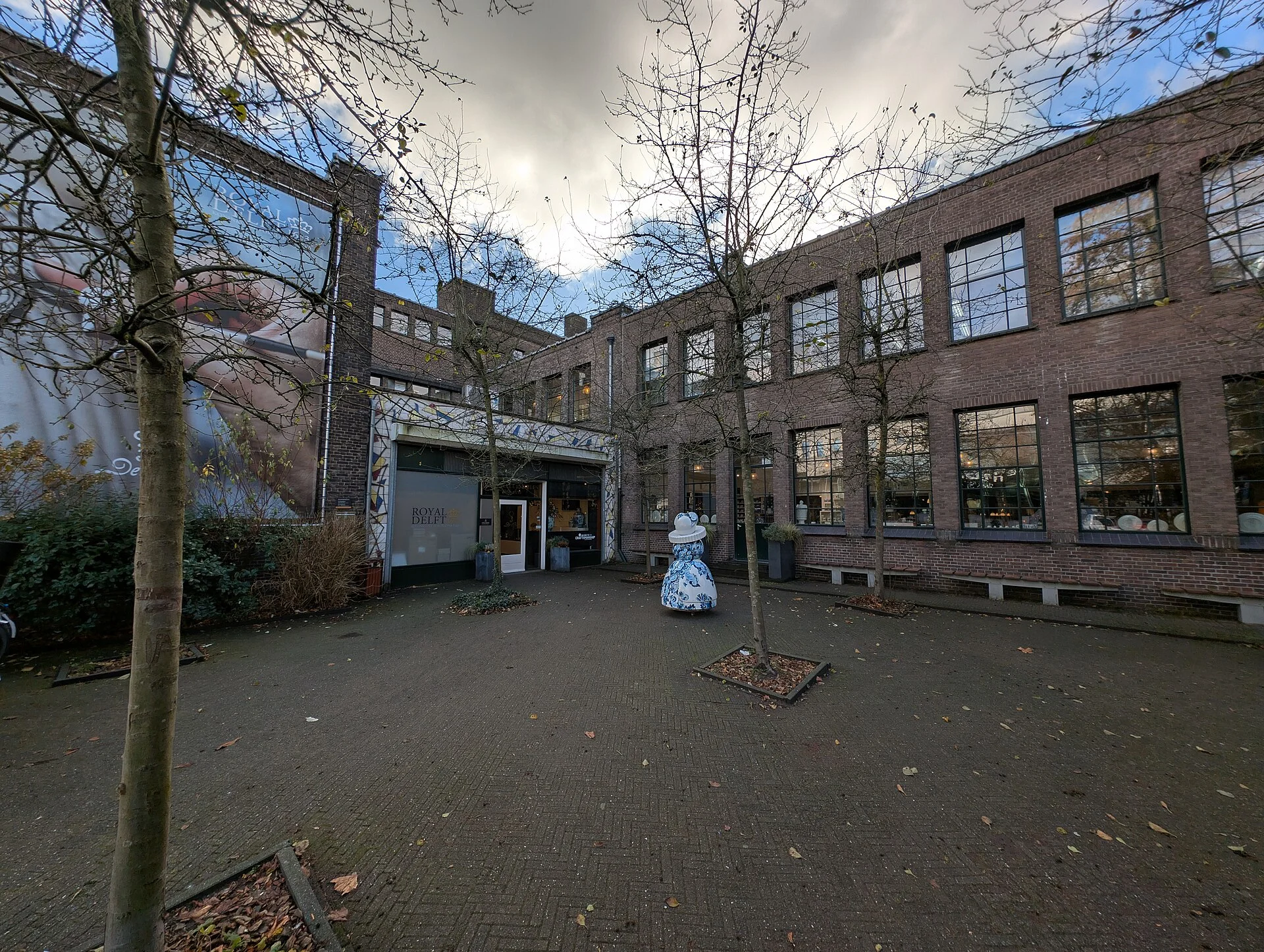 Courtyard entrance of the Royal Delft pottery with a blue-and-white dress sculpture