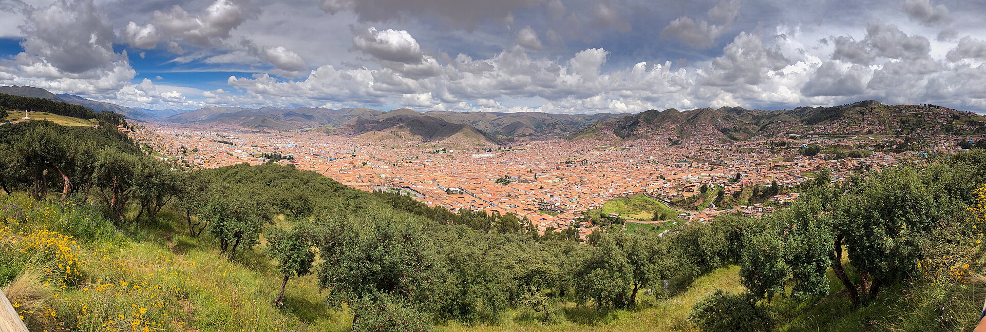Panoramic view of Cusco city from Sacsayhuaman, showing the red-roofed colonial cityscape nestled in the Andes valley