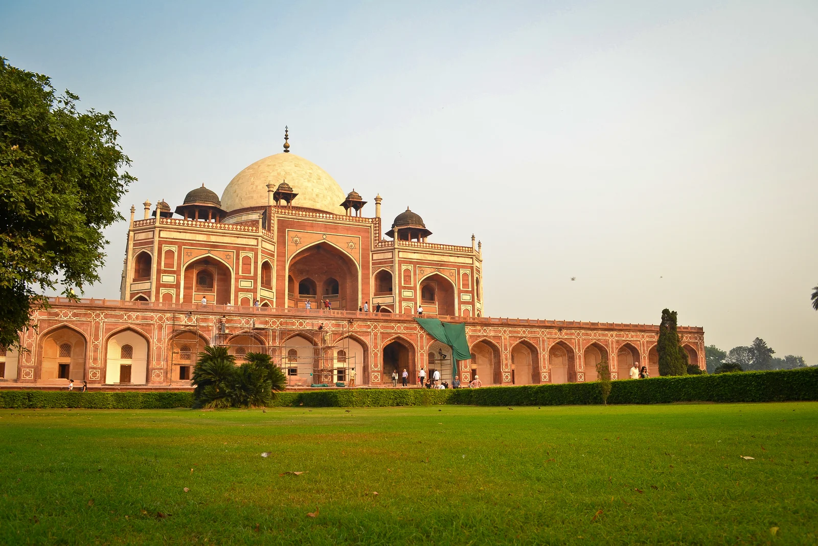 Humayun's Tomb viewed at an angle, its white marble dome and red sandstone facade above a green lawn