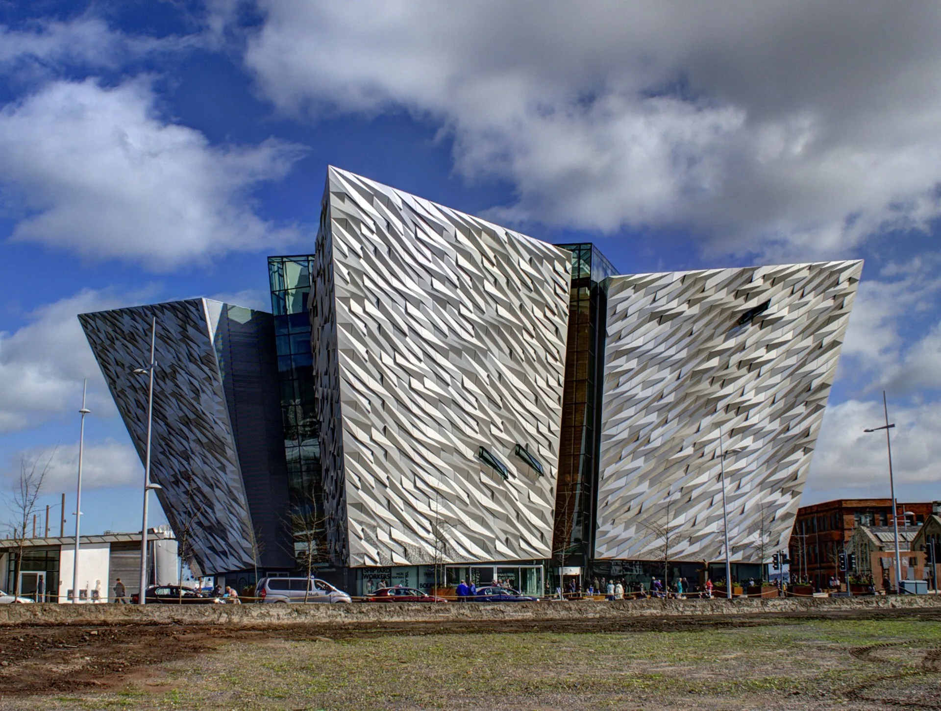 Titanic Belfast museum building at twilight, its angular bow-shaped facade reflected in the water