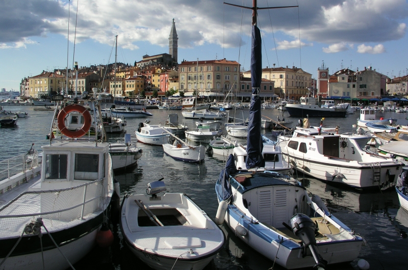 Rovinj harbour on the Istrian coast of Croatia, with its colourful buildings and the church of Saint Euphemia Rovinj's pastel-coloured fishermen's houses cascading down to the Adriatic, the Baroque Church of St Euphemia's campanile crowning the old town peninsula