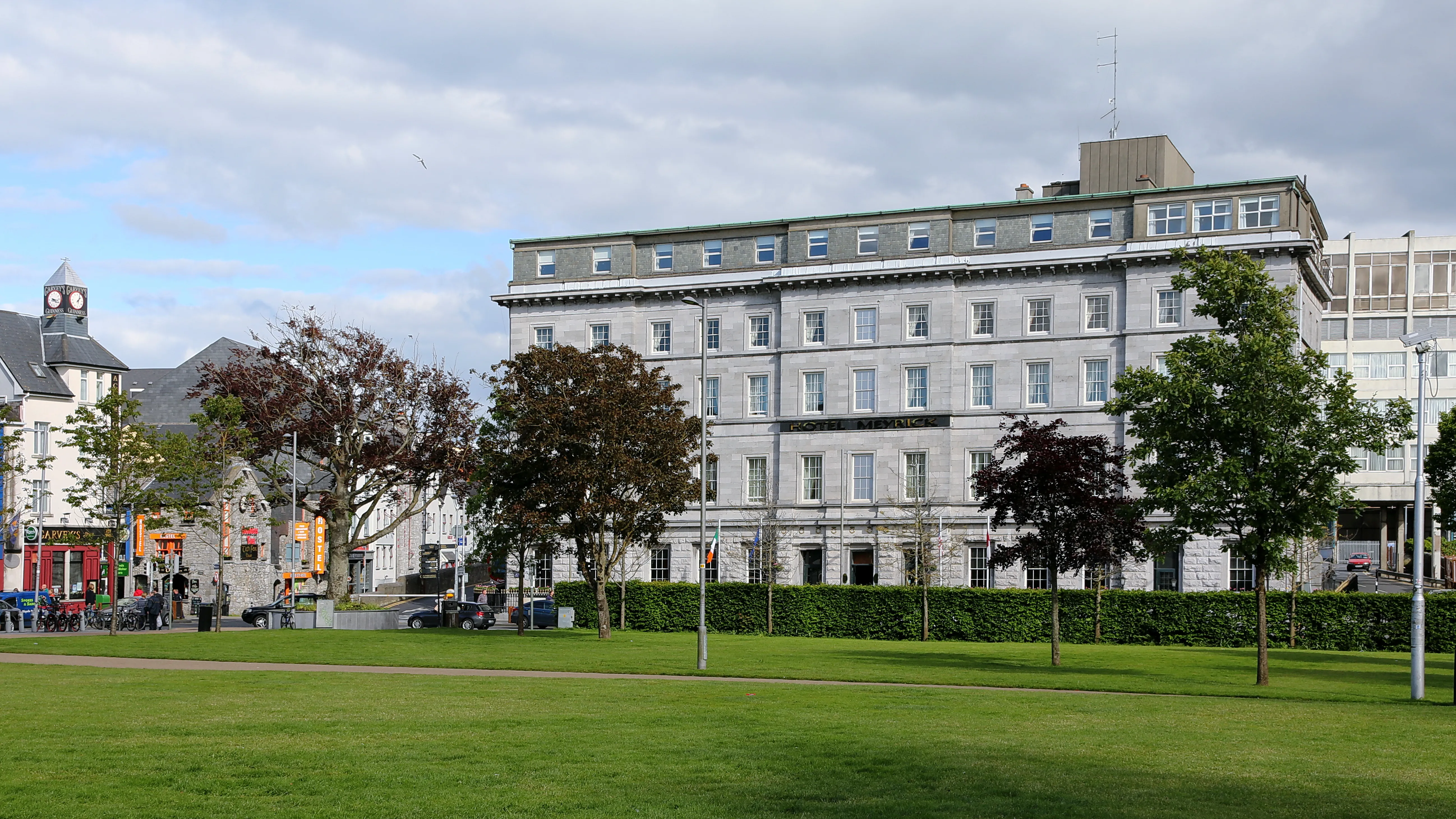The open lawns and flag banners of Eyre Square in central Galway on a bright day