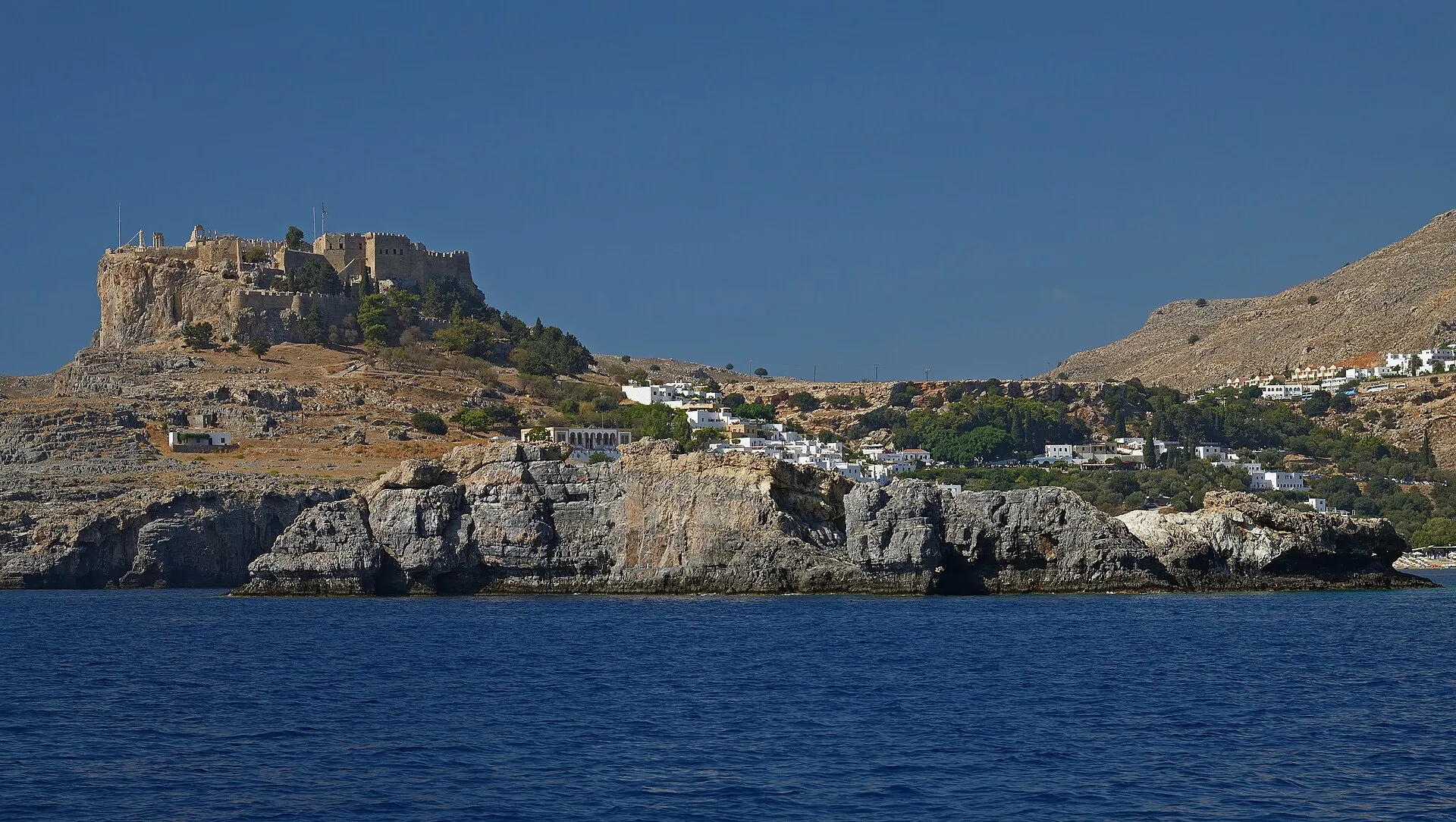 The Acropolis of Lindos on its clifftop promontory above the whitewashed village and bay, Rhodes