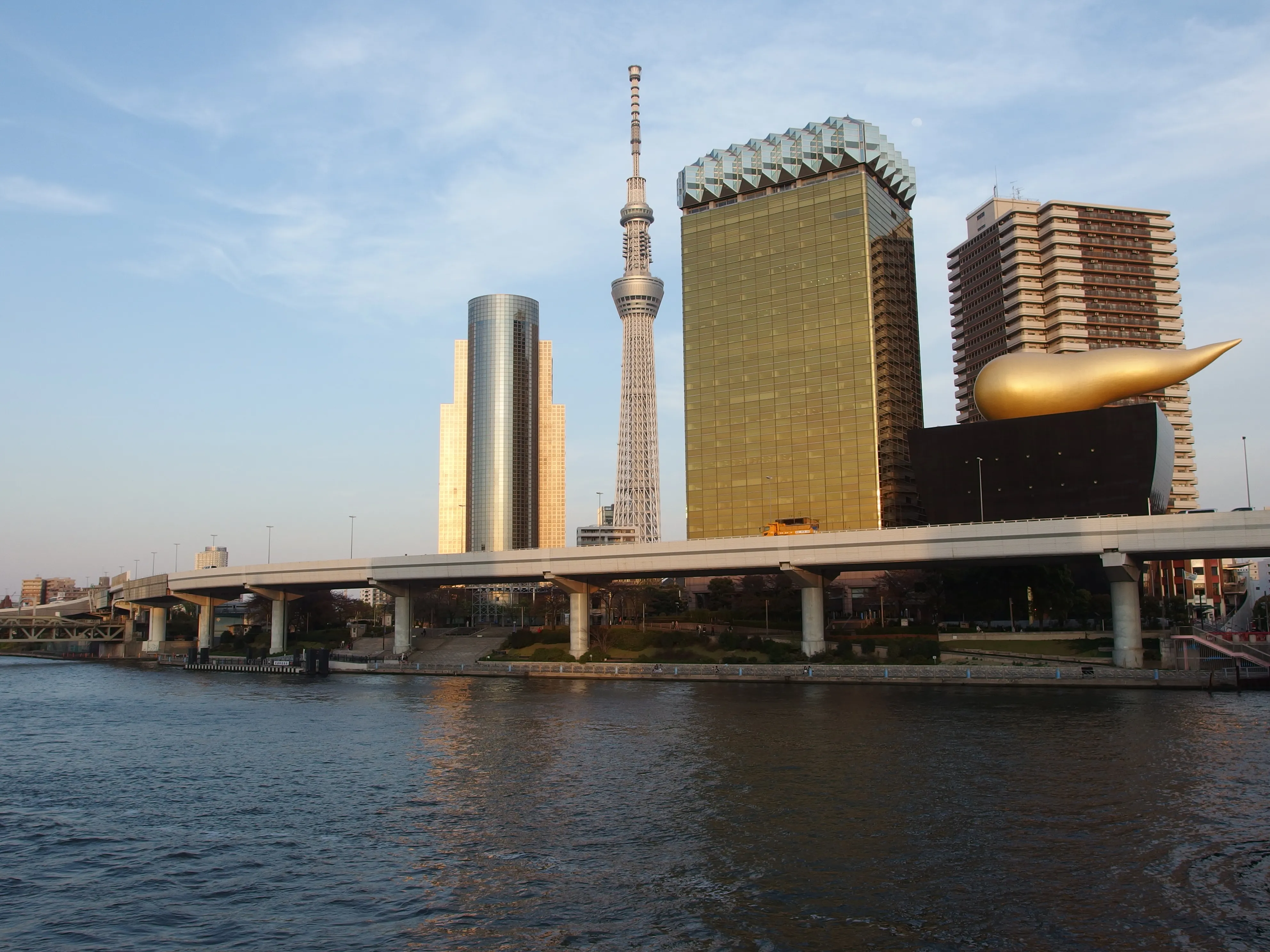 The Tokyo Skytree seen across the Sumida River with a passing boat near Asakusa