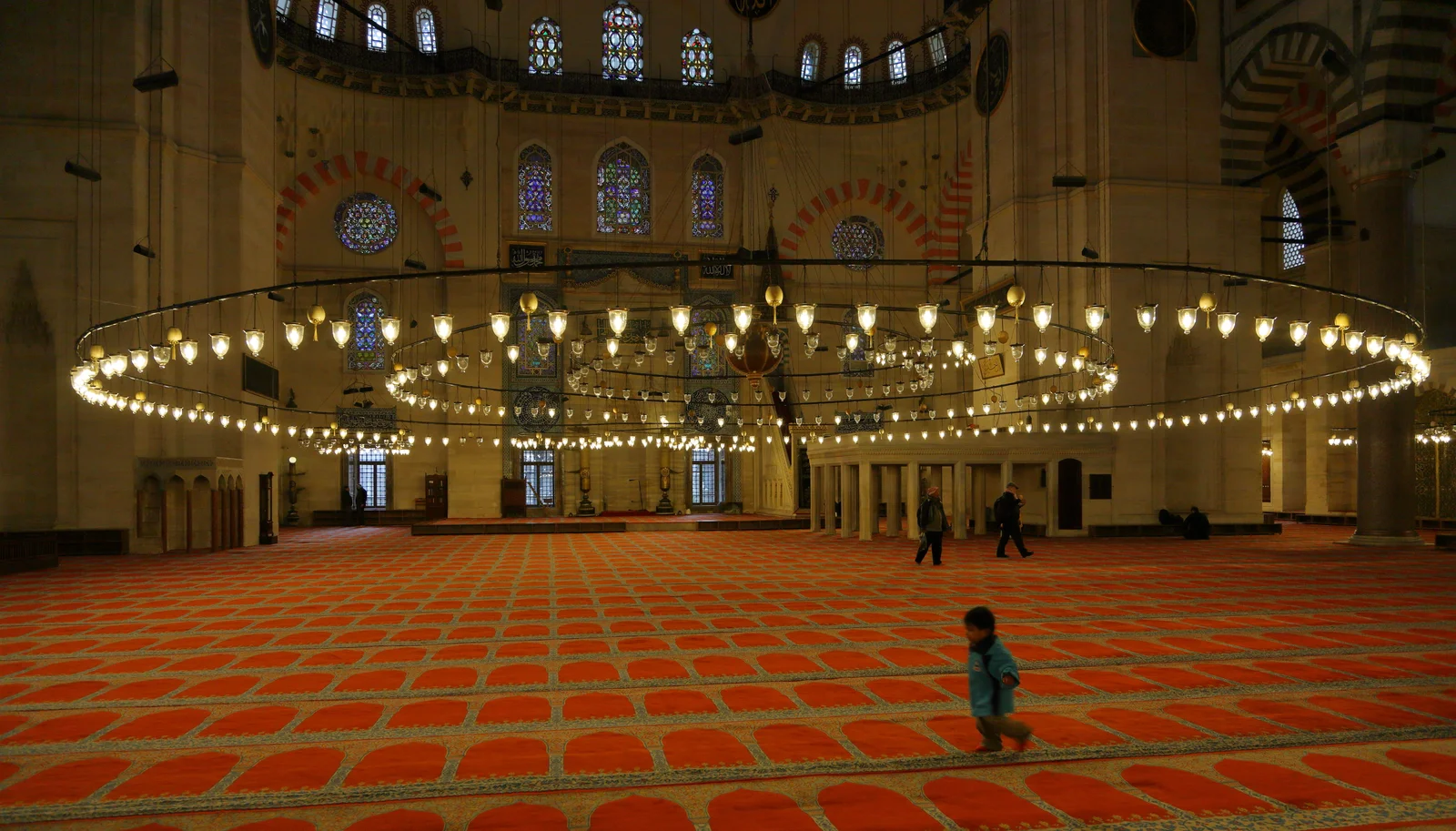 Wide low chandelier hanging beneath the painted main dome of the Suleymaniye Mosque