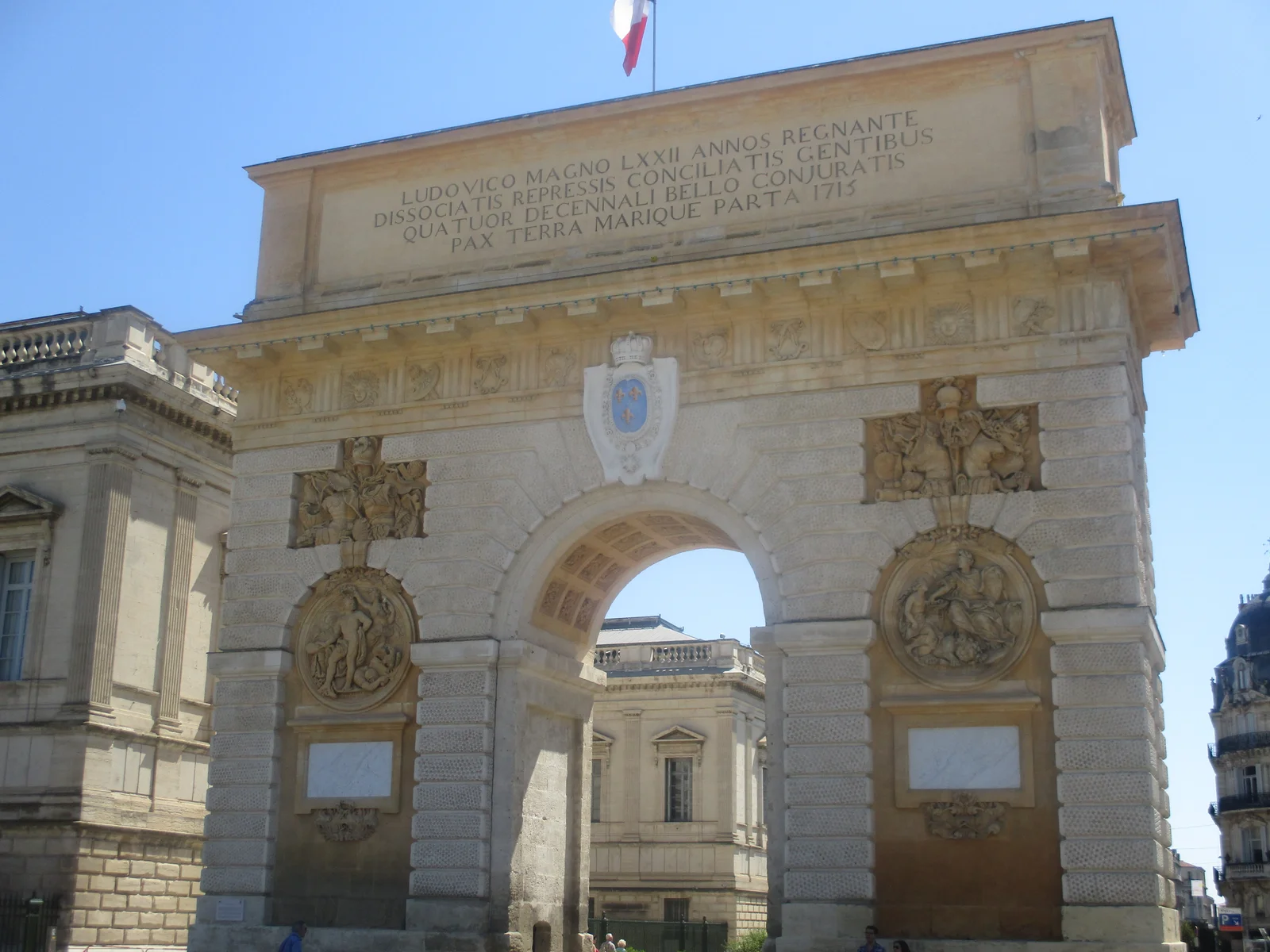 The Arc de Triomphe (Porte du Peyrou) in Montpellier seen head-on from the street under a clear blue sky