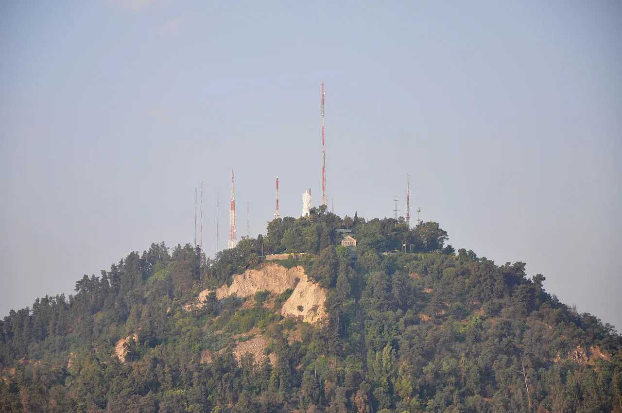 Aerial view of Cerro San Cristóbal and the Virgen statue above Santiago with the city and Andes mountains visible below