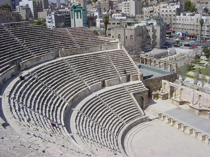 The Roman Theatre in downtown Amman, Jordan, with the city rising on the hills behind
