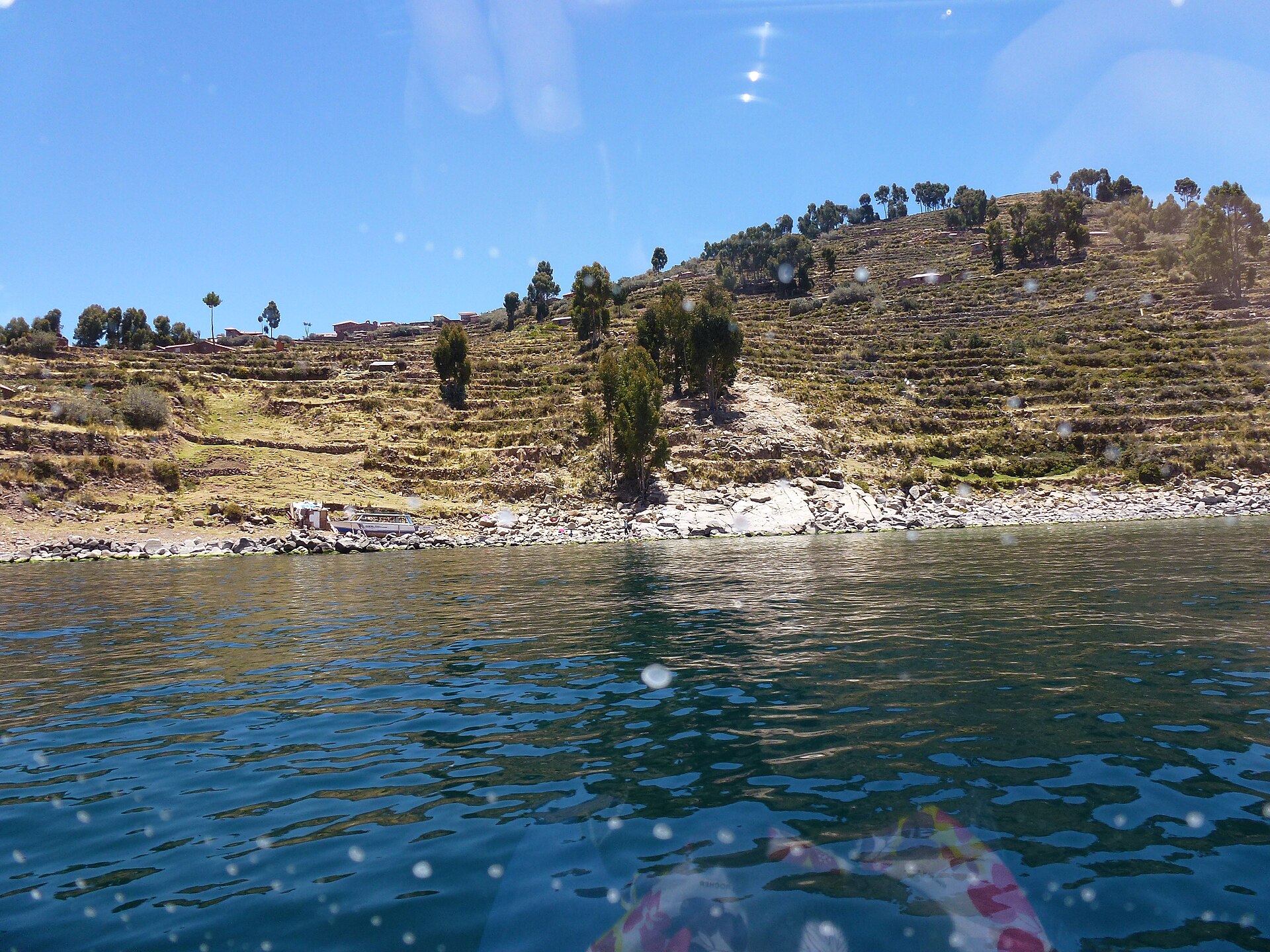 View of Lake Titicaca from Taquile Island with terraced hillsides and deep blue waters stretching to the horizon