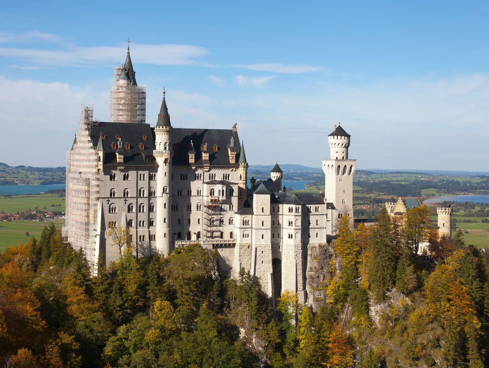 Neuschwanstein Castle seen head-on from the Marienbrücke footbridge, its white towers rising above the forested Pöllat Gorge