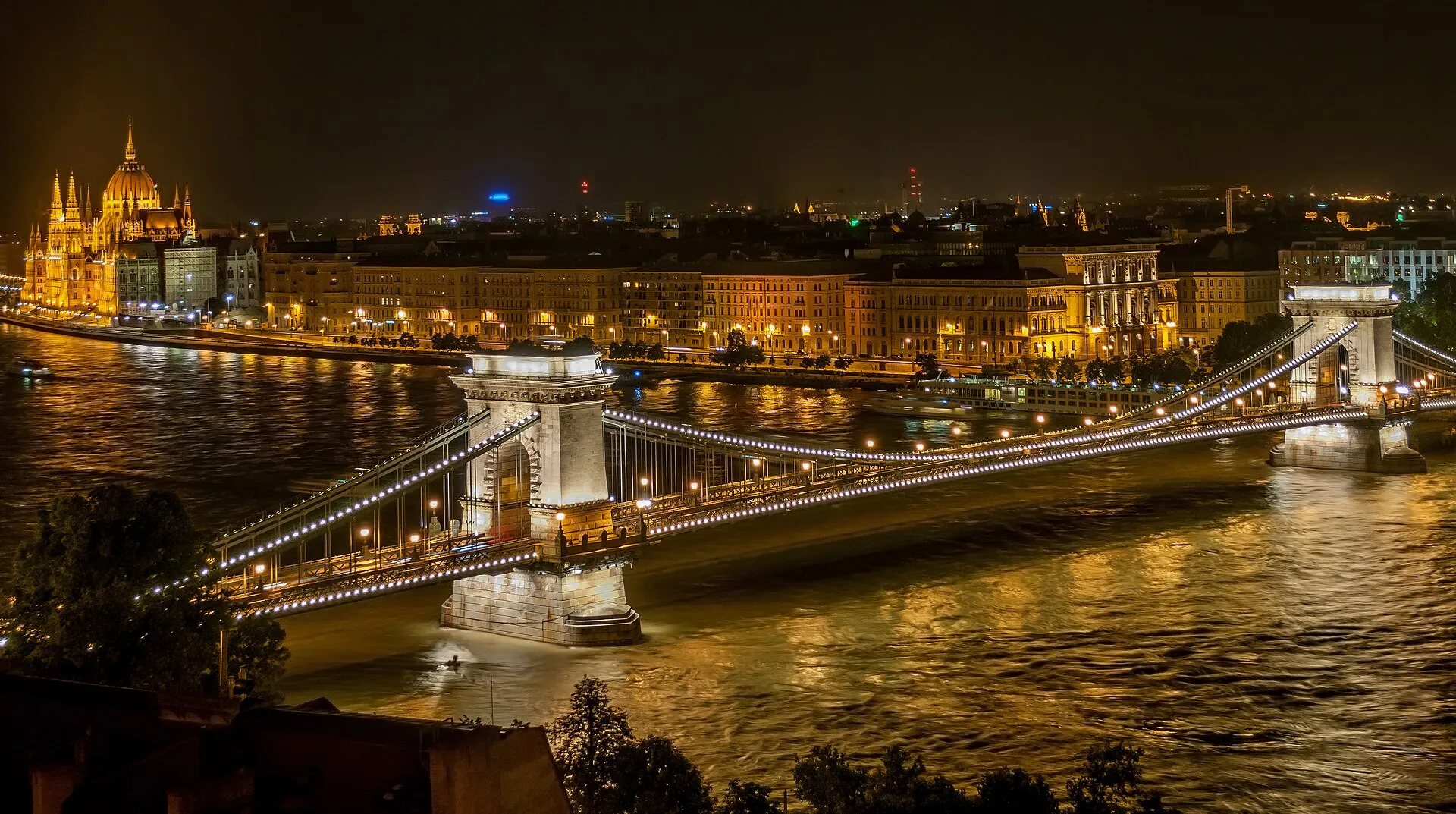 Széchenyi Chain Bridge illuminated at night, with Buda Castle visible on the hill above