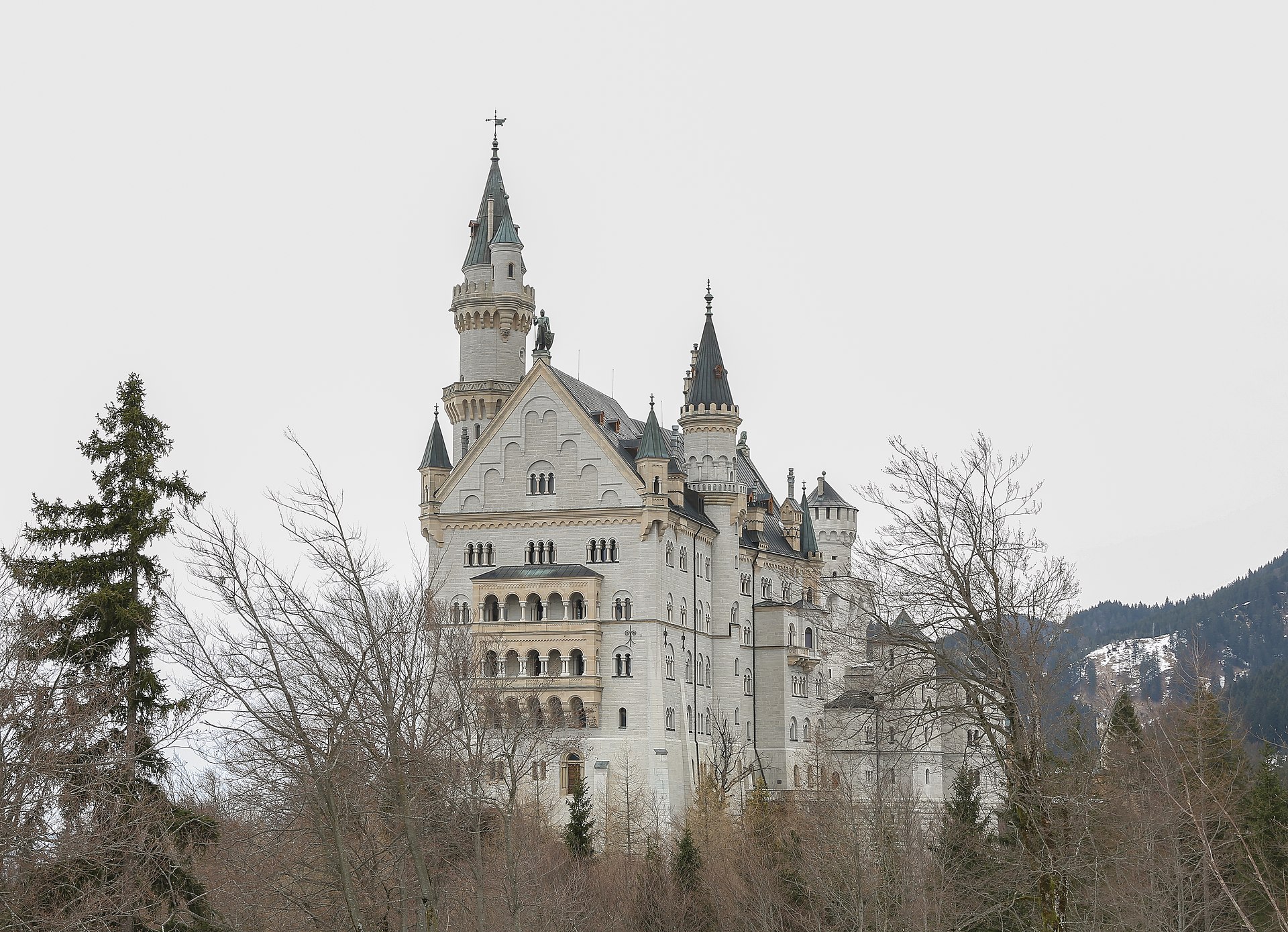 Neuschwanstein Castle perched on a wooded hilltop in the Bavarian Alps, Germany