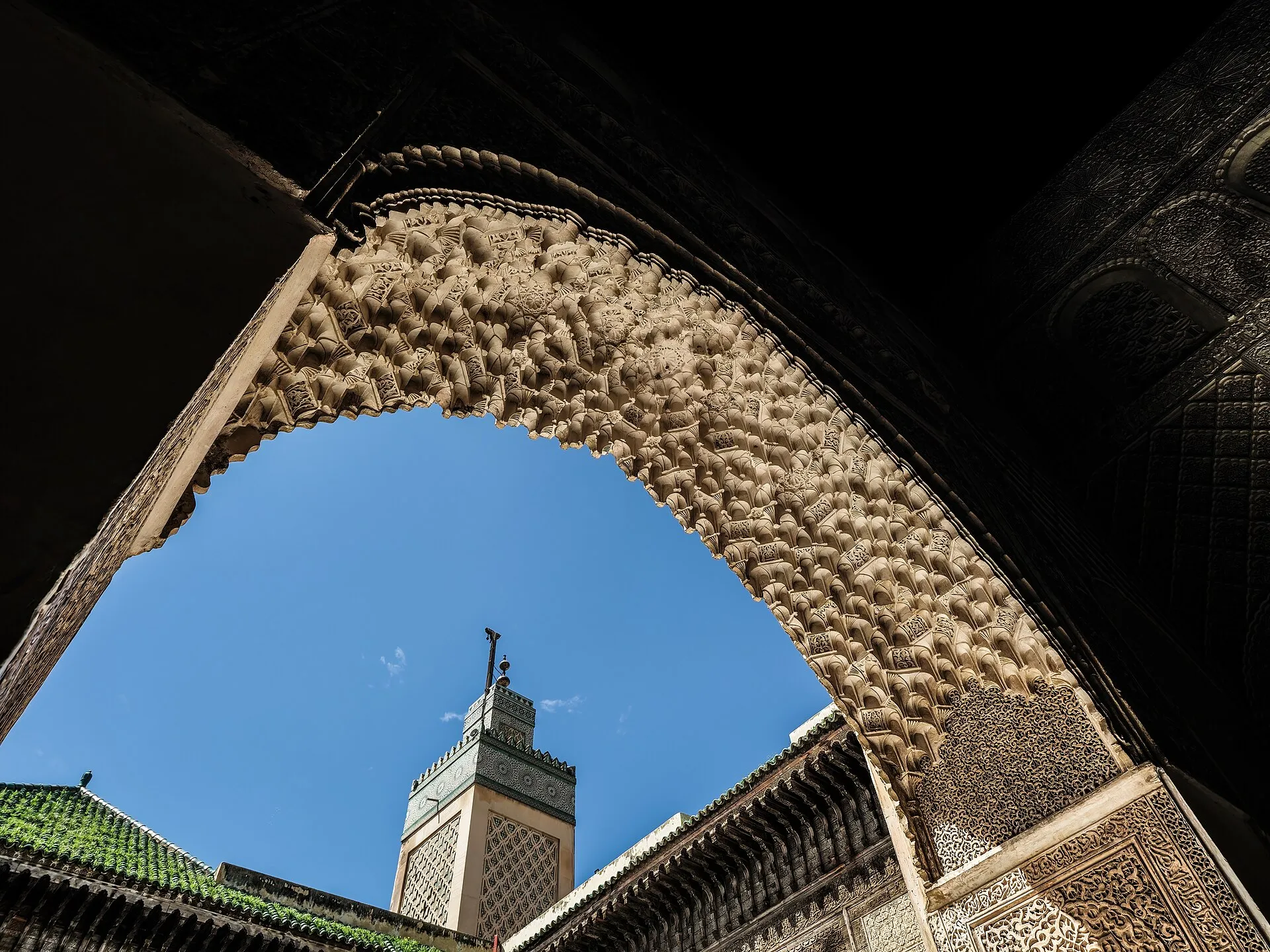 Interior courtyard of Bou Inania Madrasa in Fez with carved stucco and zellige