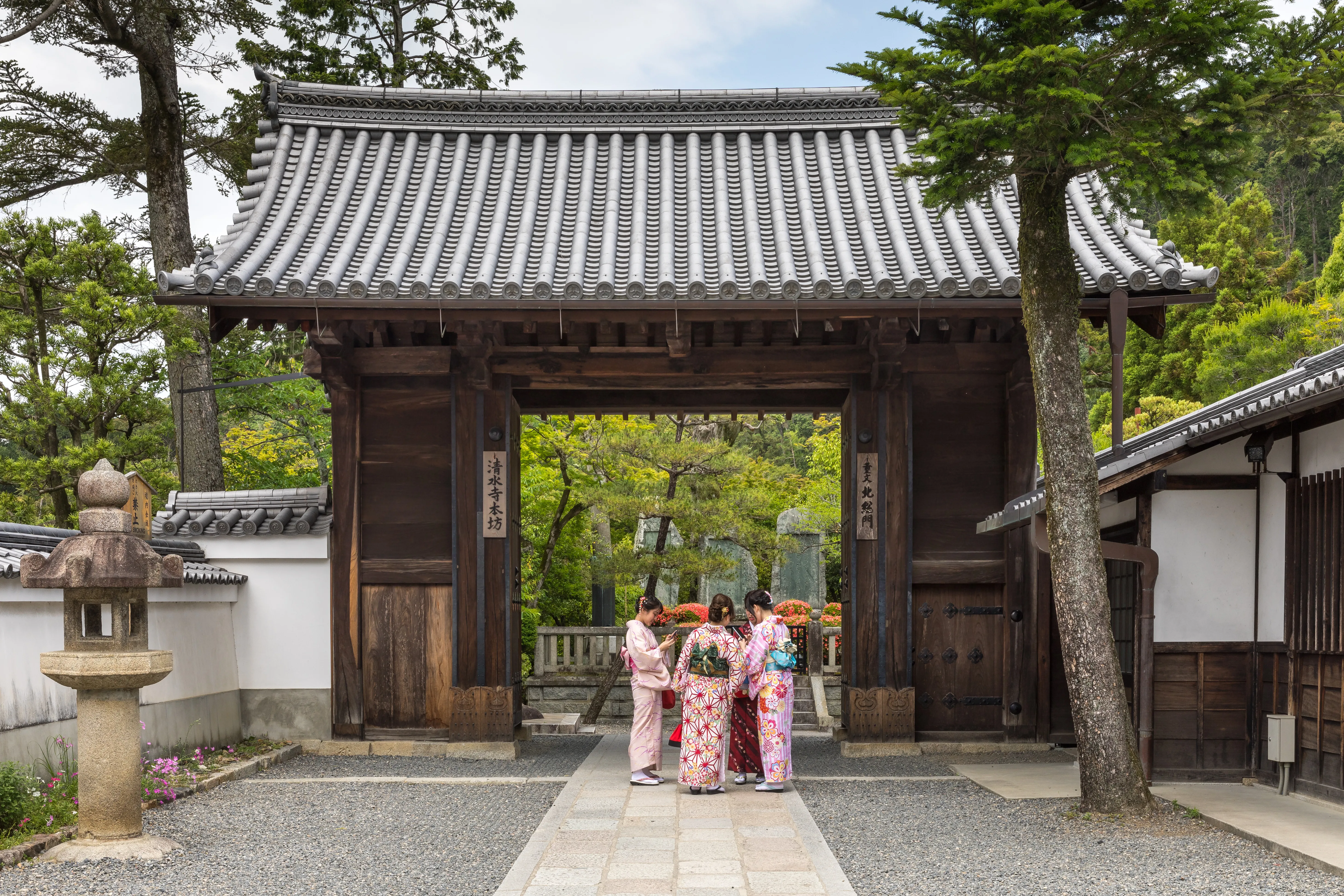 Four women in colourful yukata standing before the vermilion North Gate of Kiyomizu-dera in Kyoto