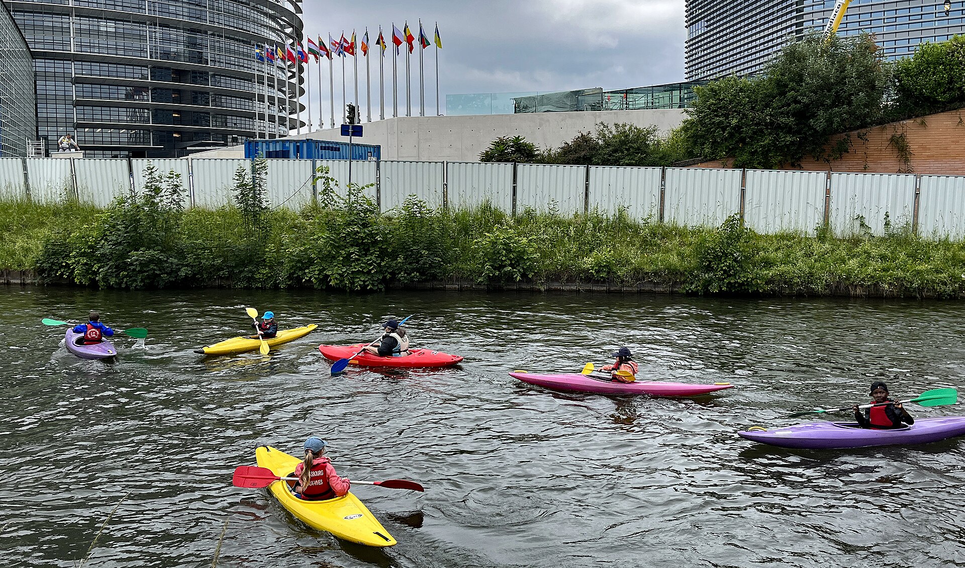 European Parliament building in Strasbourg with flags along the riverside