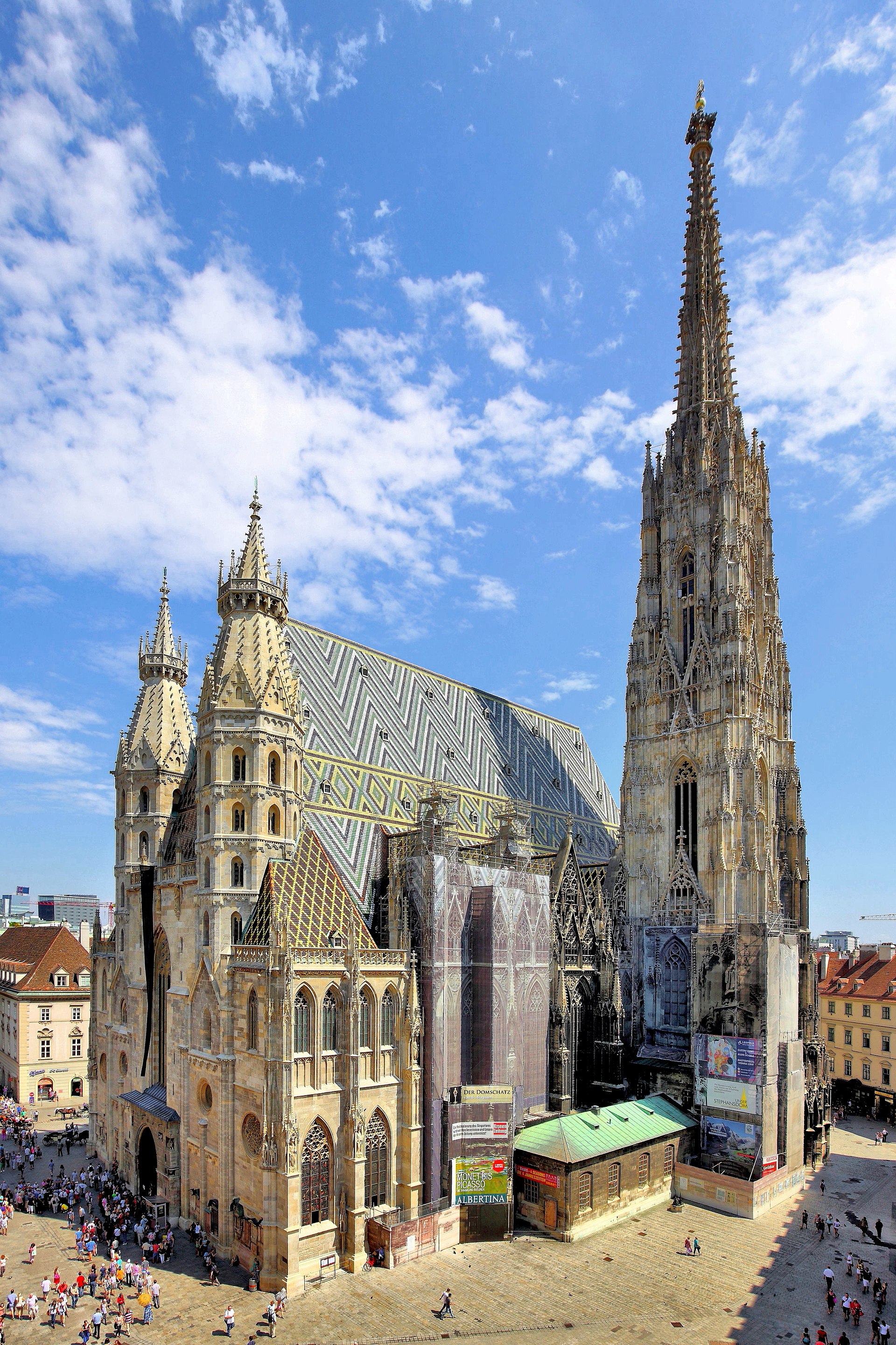 St. Stephen's Cathedral in Vienna showing its multi-colored chevron tile roof and towering Gothic south spire against a blue sky