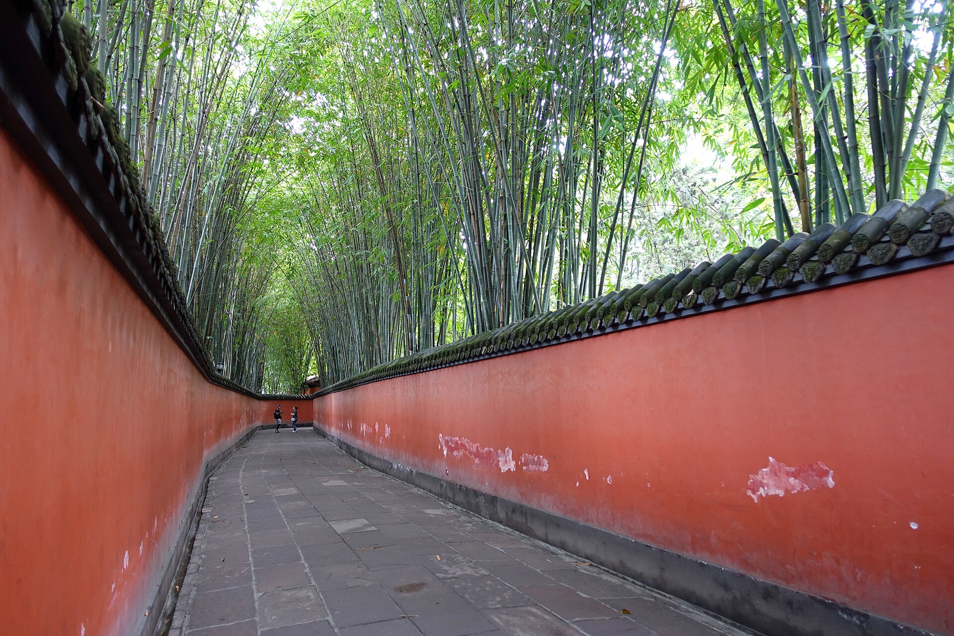 Red wall corridor pathway at Wuhou Shrine in Chengdu surrounded by lush greenery
