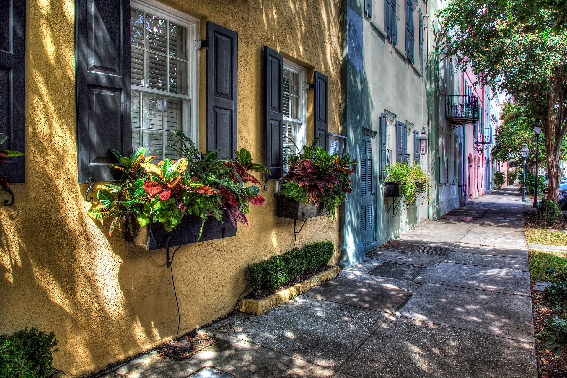 Wide-angle view of the pastel-colored Georgian rowhouses of Rainbow Row on East Bay Street in Charleston