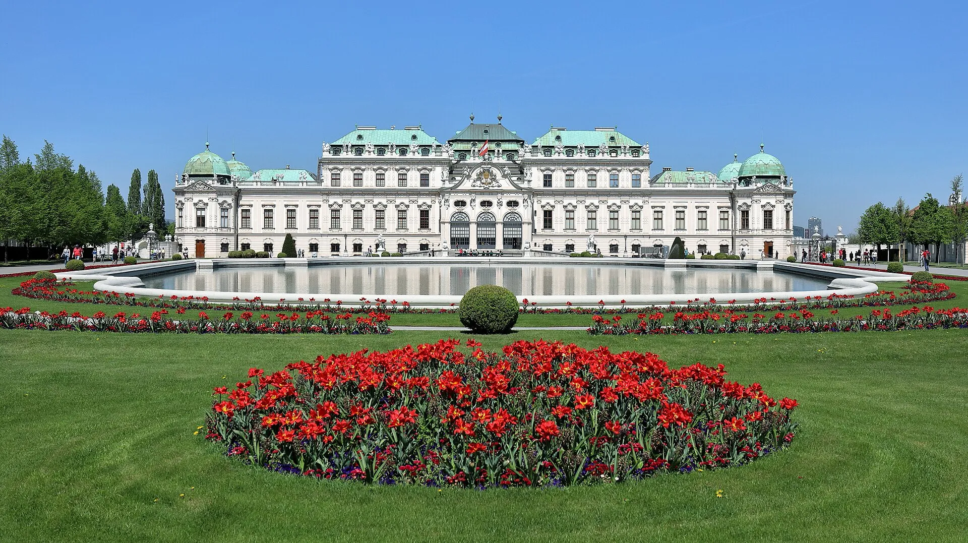 The Upper Belvedere Palace in Vienna, its baroque facade reflected in the ornamental fountain pool among manicured gardens