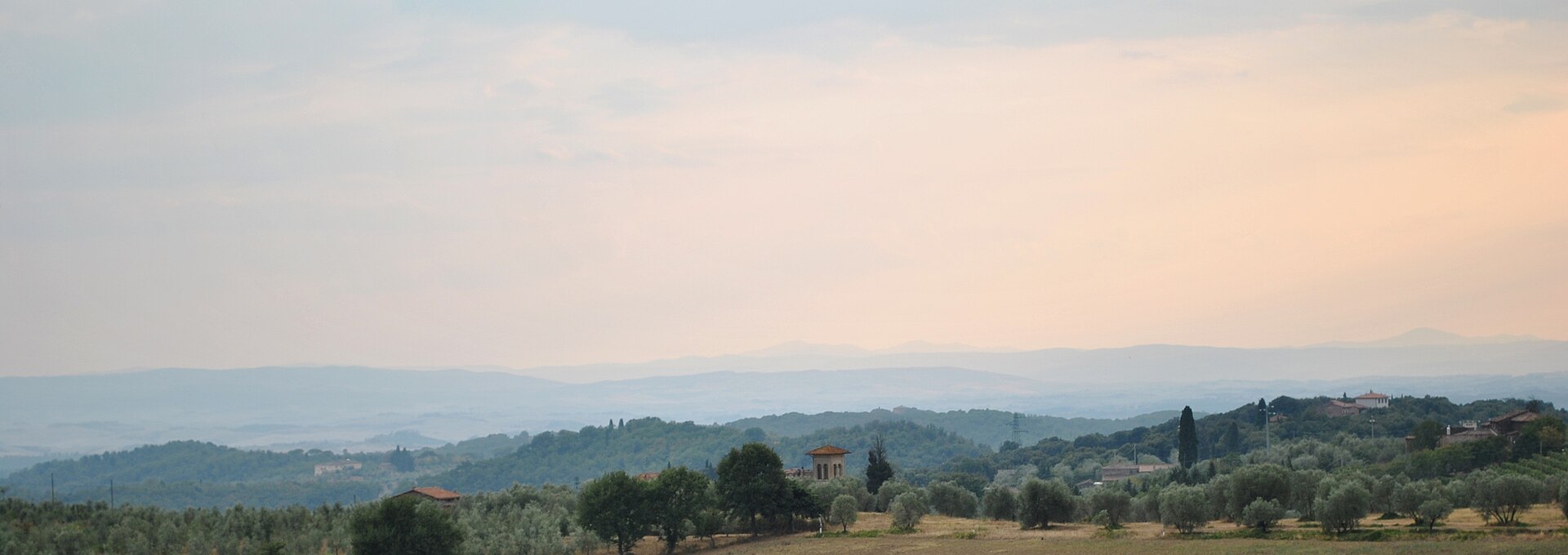 Rolling green hills and cypress trees of the Tuscan countryside in Italy