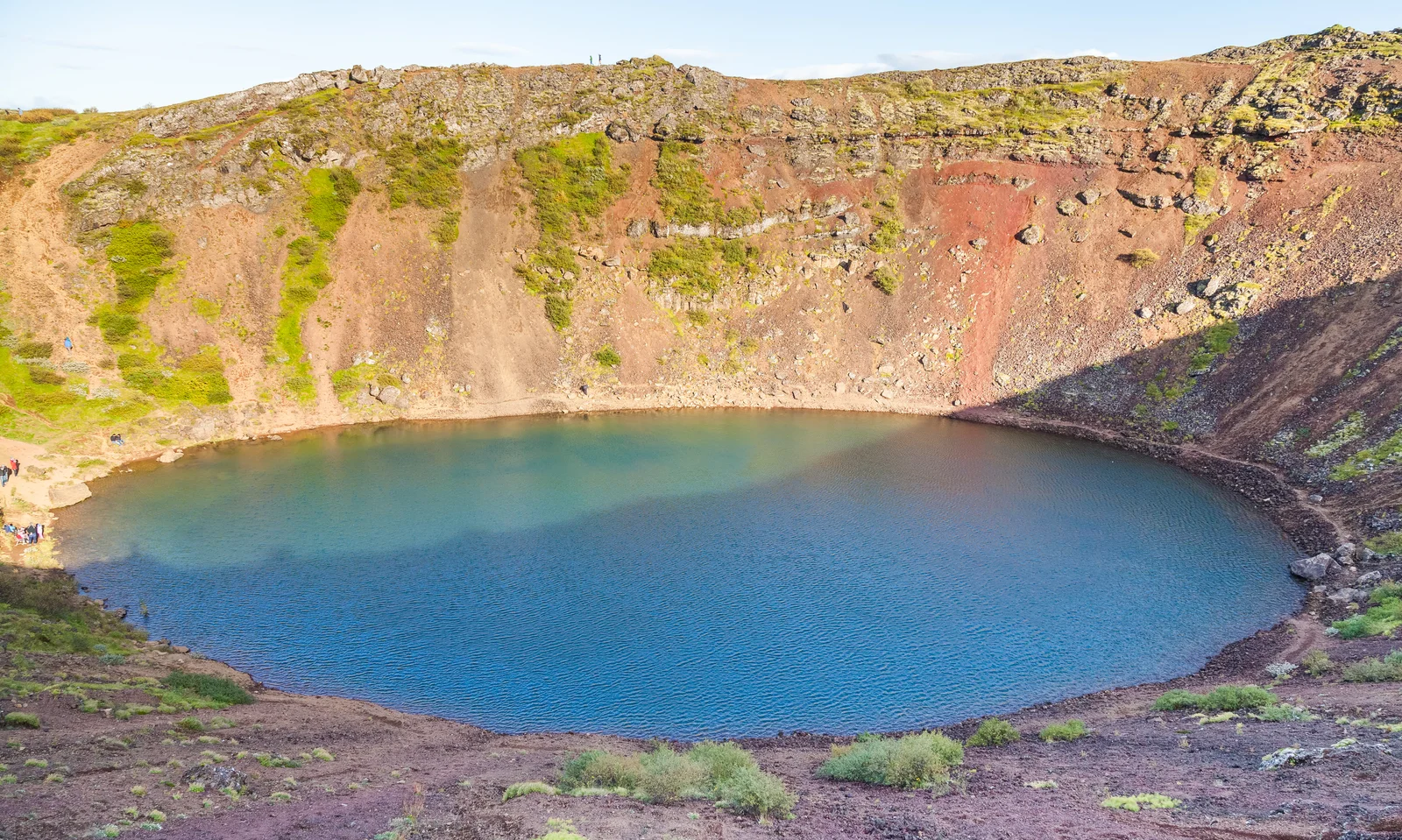 The red volcanic slopes and turquoise crater lake of Kerið near Selfoss in South Iceland