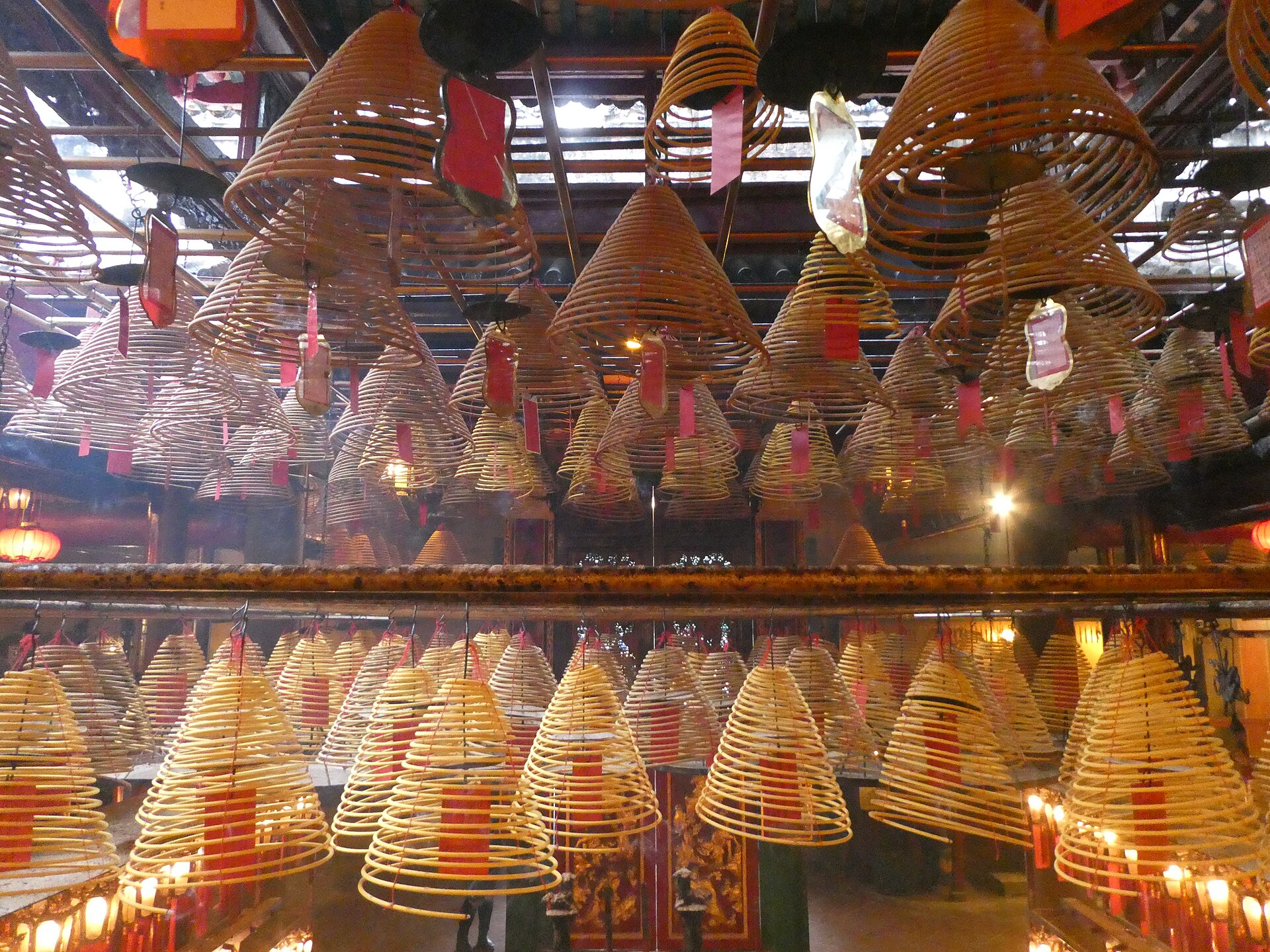 Burning spiral incense coils hanging from the ceiling inside Man Mo Temple in Hong Kong