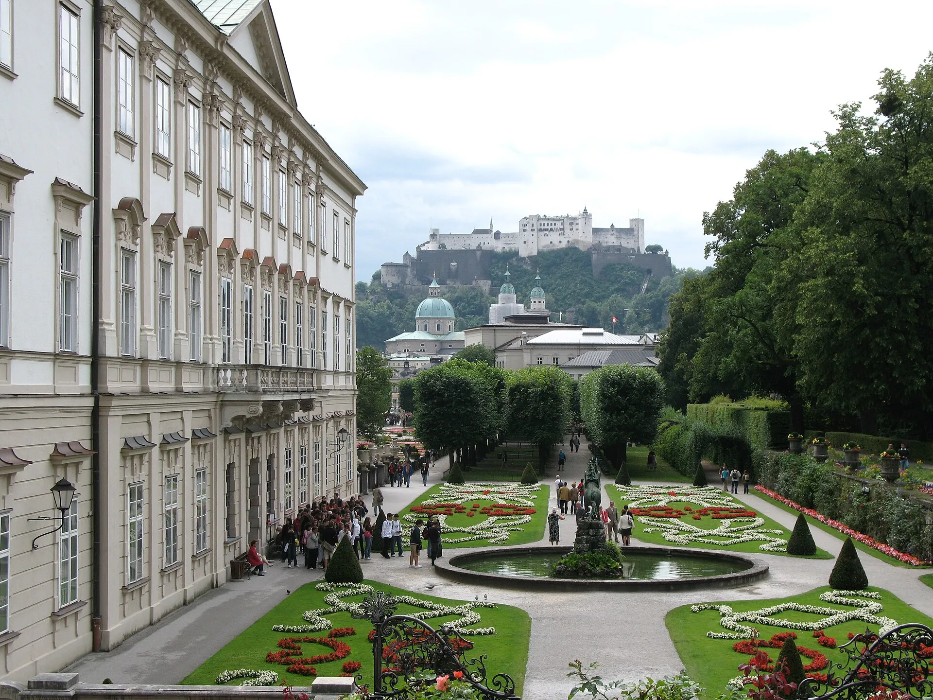 Mirabell Gardens' baroque parterre looking towards Salzburg's cathedral domes and Hohensalzburg Fortress on the hill