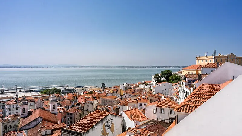 Alfama neighbourhood rooftops with the Tagus River in the background