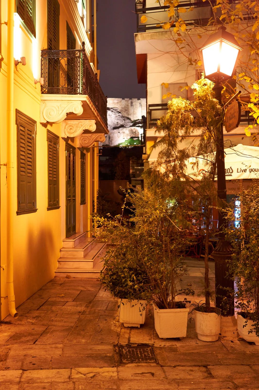 Narrow Geronta Street in Plaka framing the Acropolis in the distance