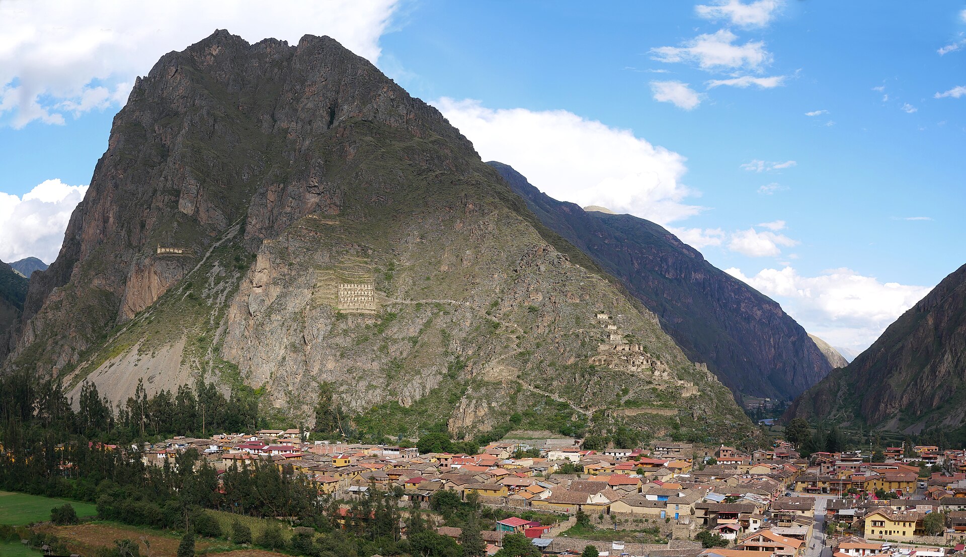 Panoramic view over the town of Ollantaytambo in the Sacred Valley of the Incas, with Inca granary ruins on the hillside above