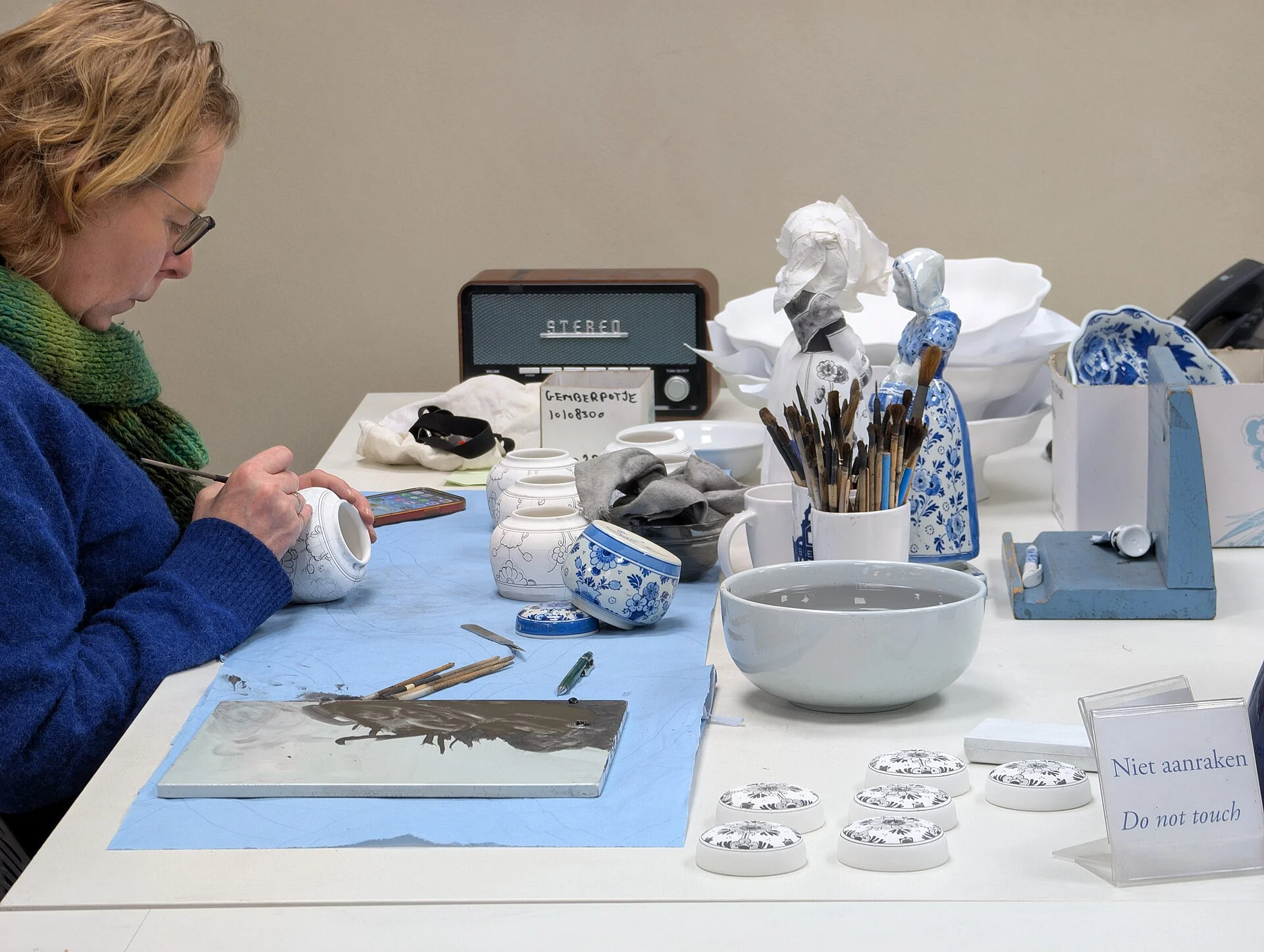 Artist hand-painting a Delftware pot at Royal Delft