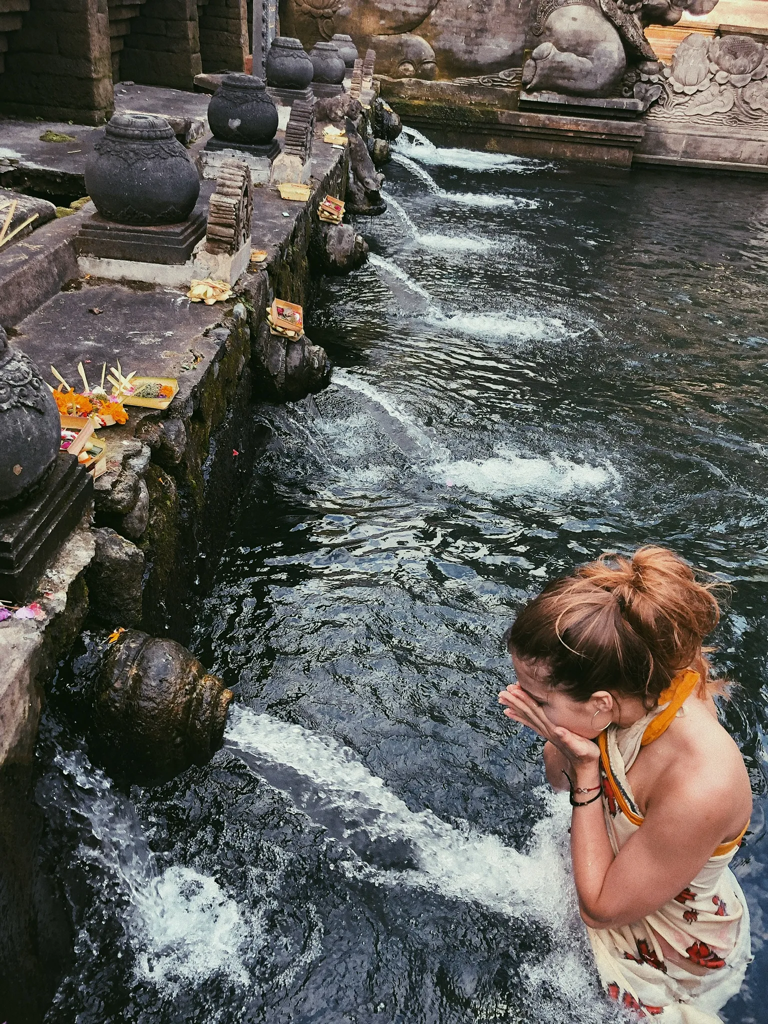 Tirta Empul Temple bathing complex with stone fountain spouts and Balinese Hindu shrines in Tampaksiring, Bali