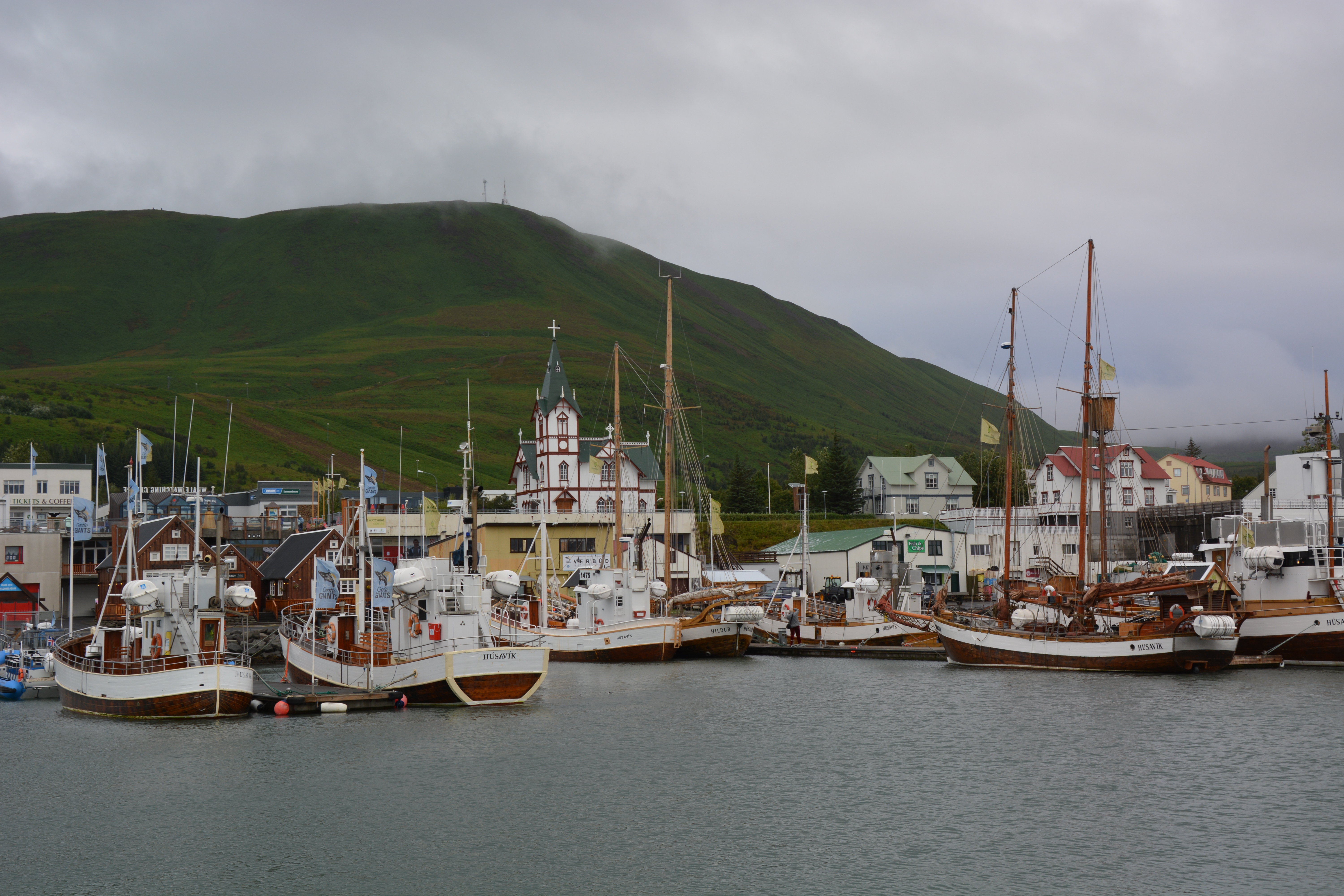 Húsavík's traditional colourful wooden church overlooking the harbour where whale watching boats depart into Skjálfandi Bay, one of Europe's most reliable whale watching spots