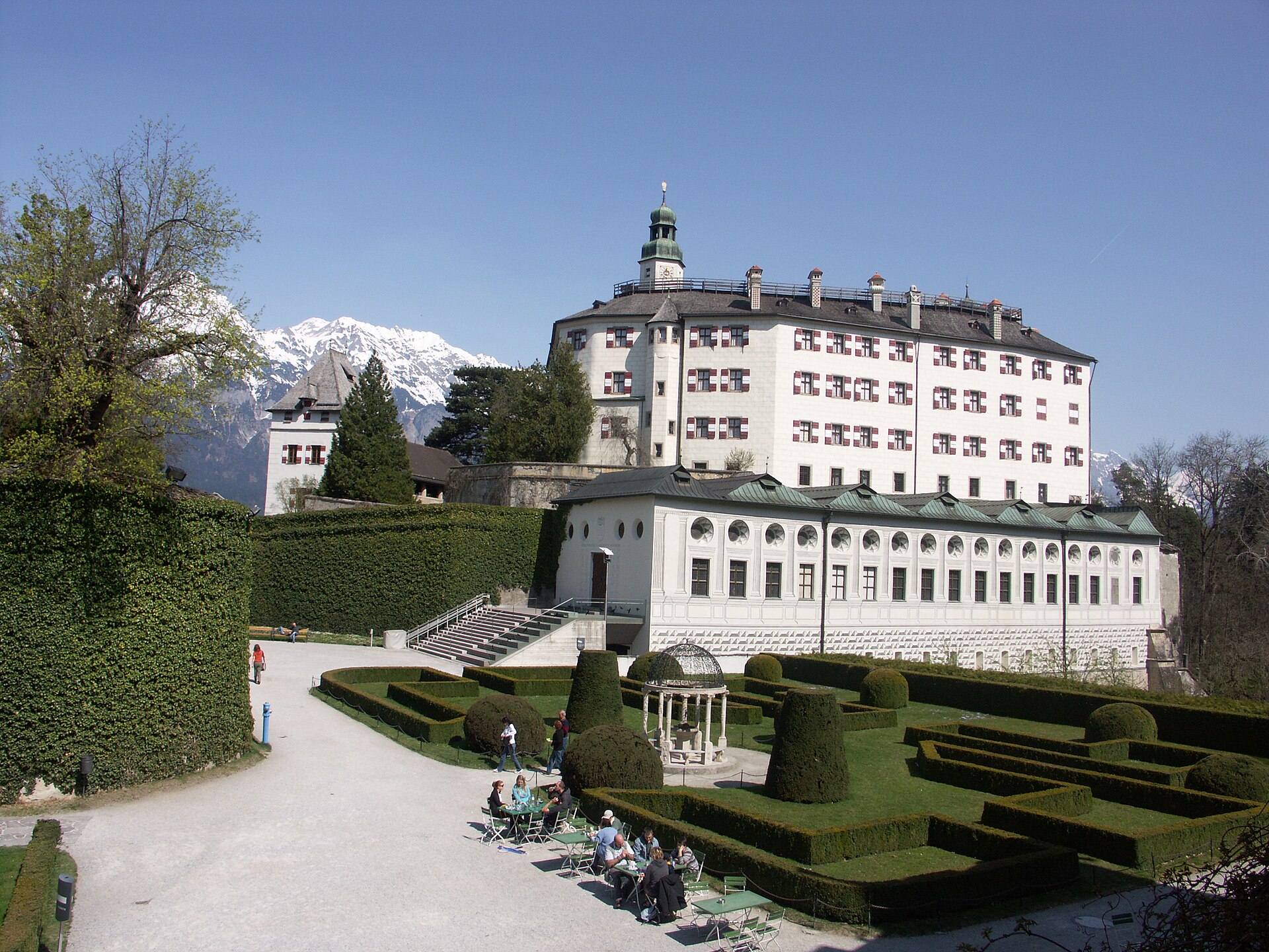 Exterior view of Ambras Castle near Innsbruck with the Renaissance palace set against a backdrop of Alpine mountains and gardens